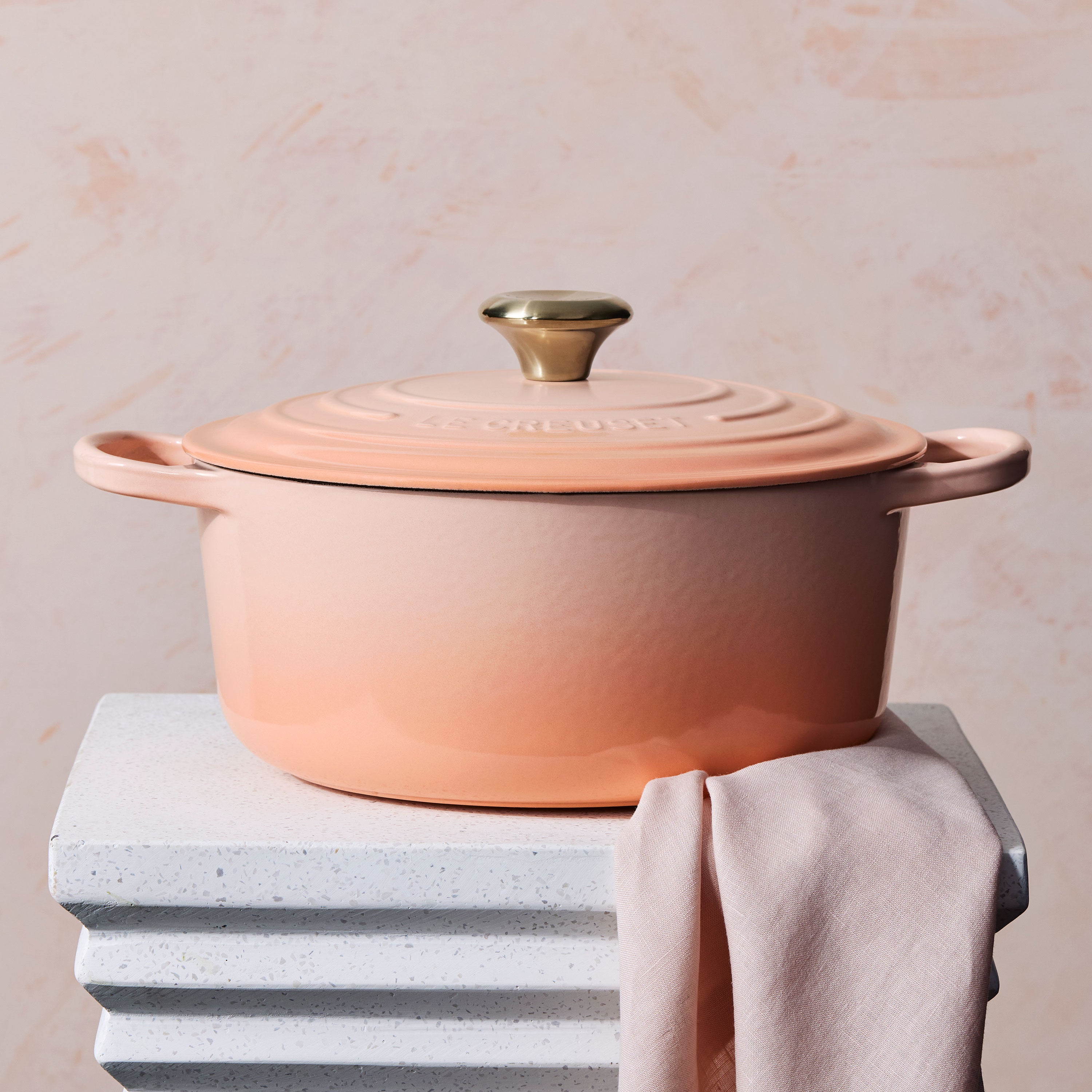 Close-up of the light gold stainless steel knob on the Le Creuset enameled Dutch oven, emphasizing its quality and heat resistance.