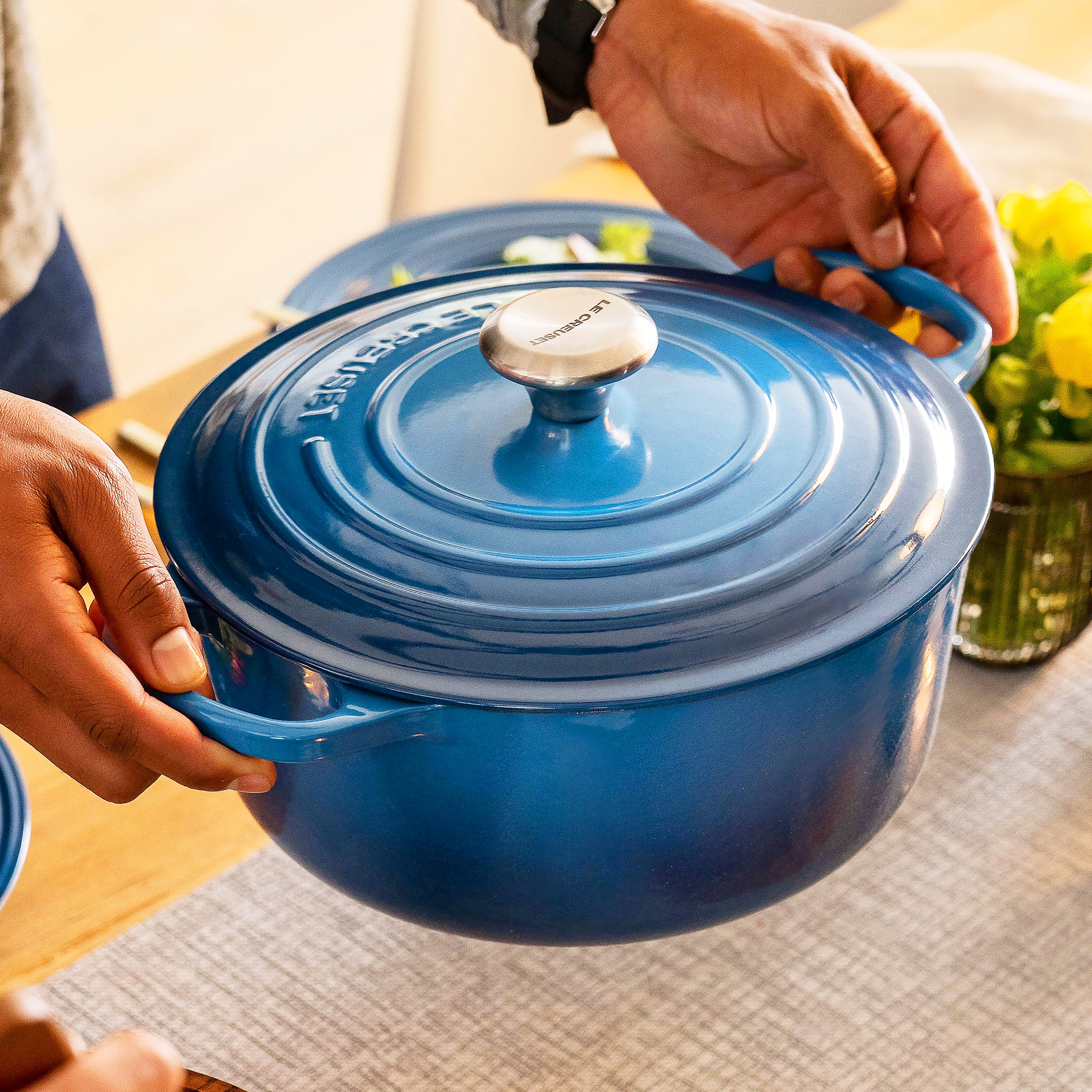 Dutch oven in use on a stovetop, steaming vegetables with lid on