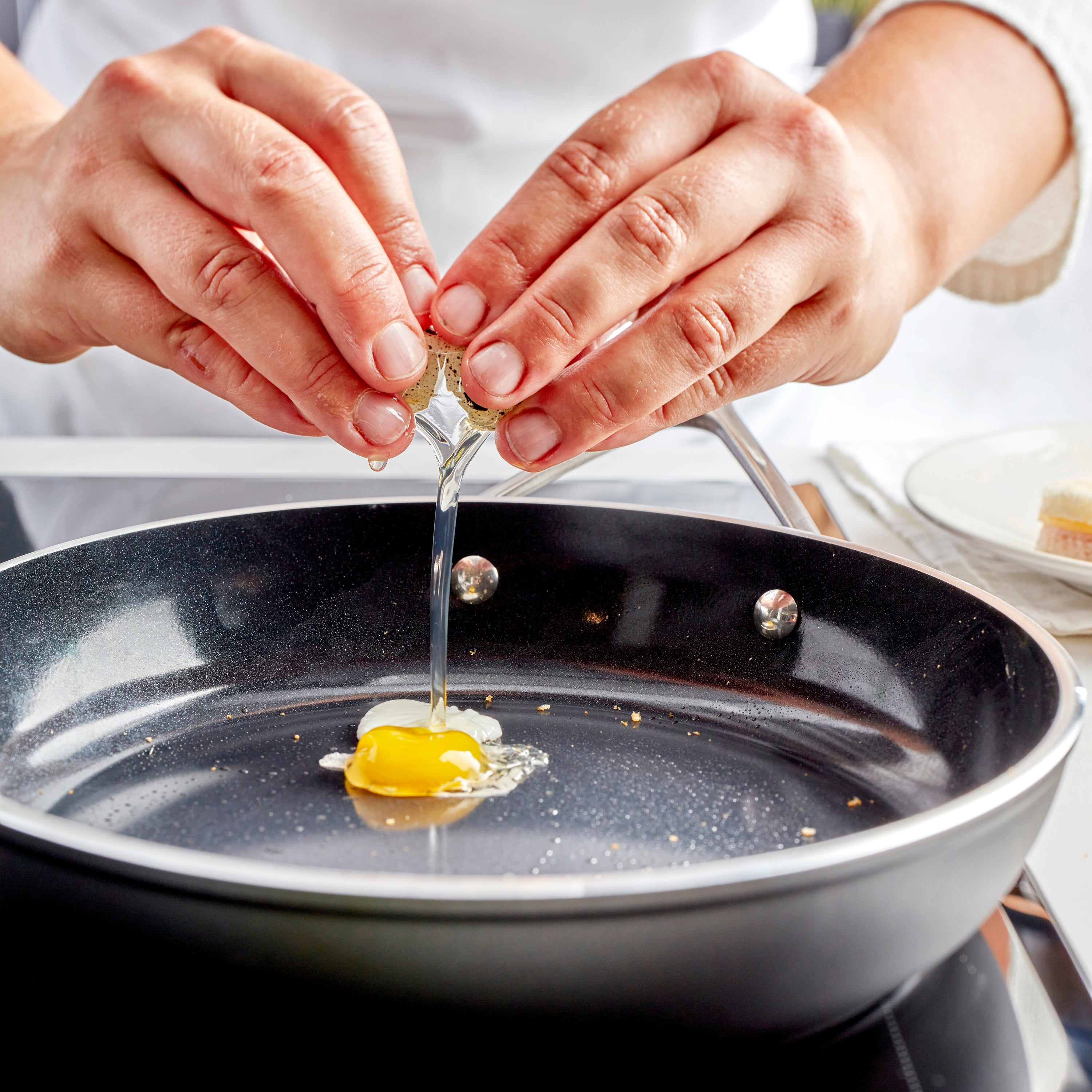Ceramic nonstick fry pan with stainless steel handle on induction stove for even cooking