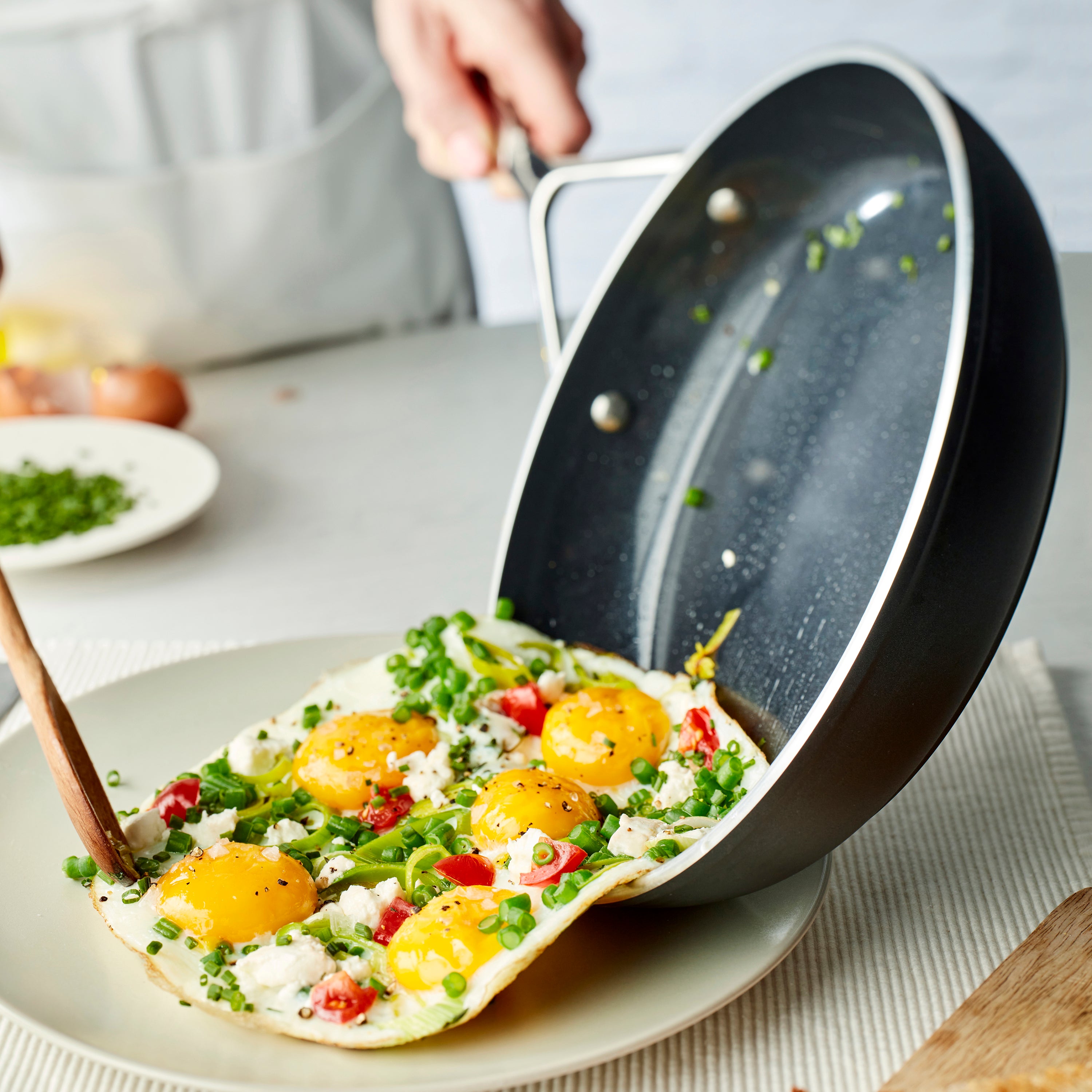 Demeyere AluPro 10" Ceramic Fry Pan being used for sautéing vegetables, illustrating its nonstick capabilities.