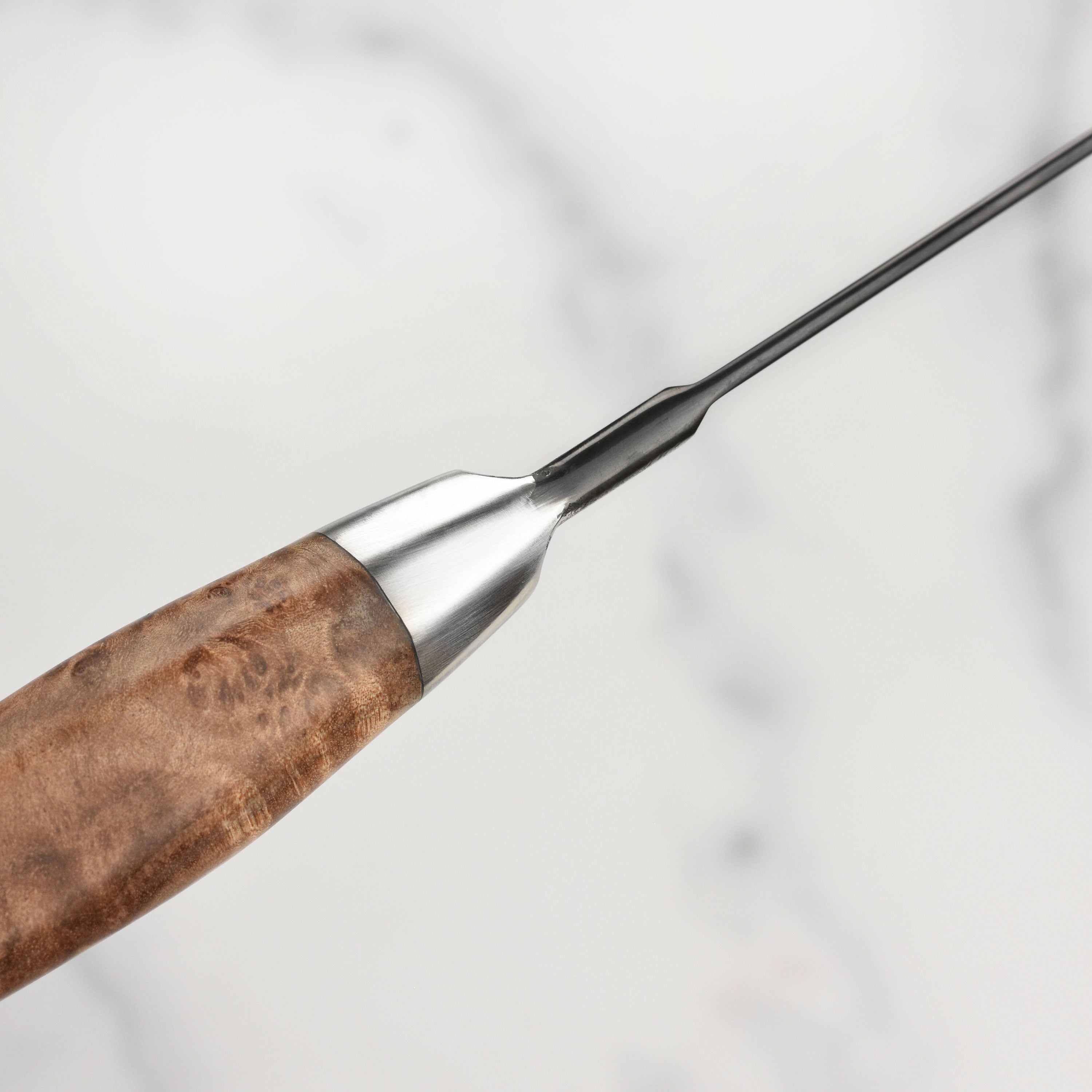 Close-up of the engraved Steelport logo on the knifes end cap, highlighting craftsmanship.