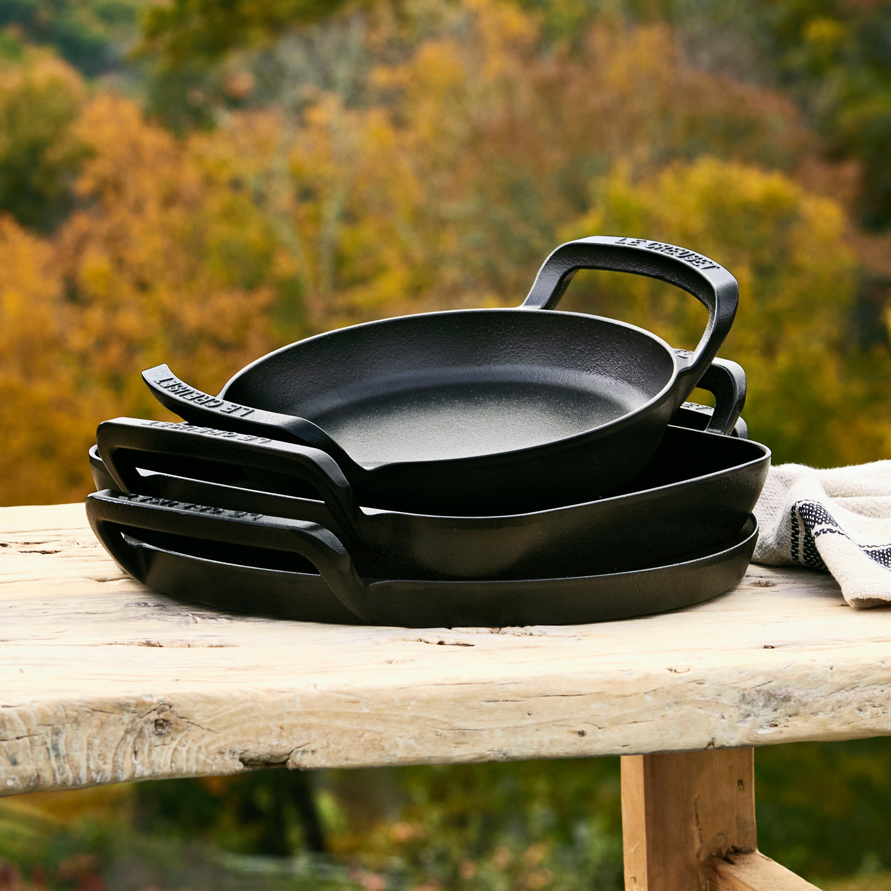 Top-down view of the Le Creuset Alpine cast iron skillet showing matte black enamel and spacious cooking surface — perfect outdoor cookware for grilling