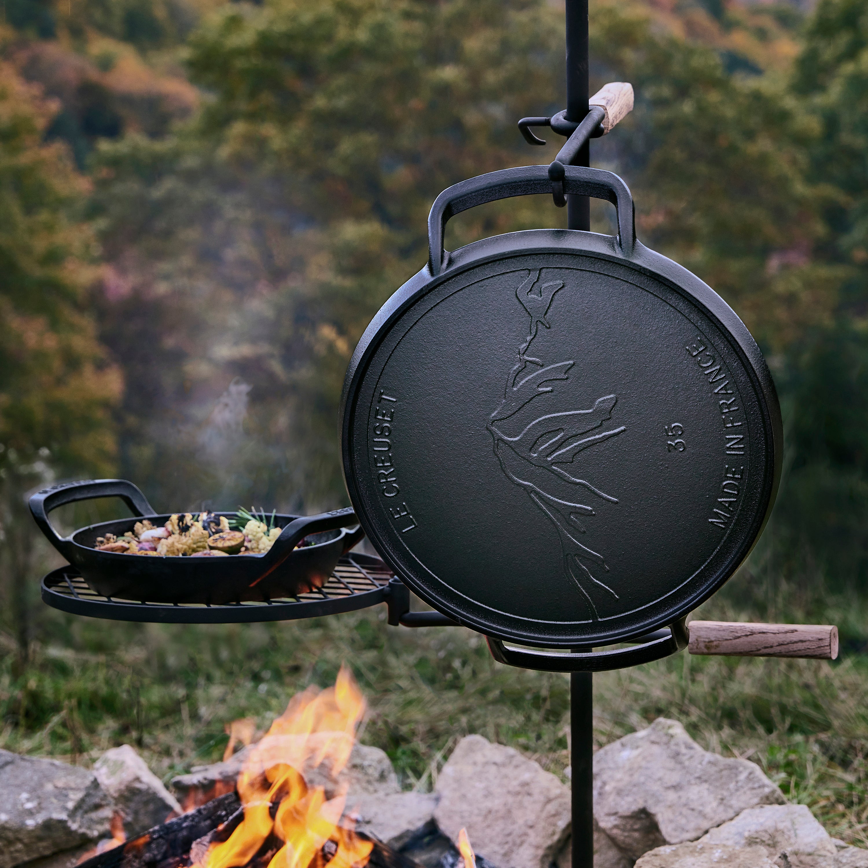 Le Creuset pizza pan being lifted with grill gloves