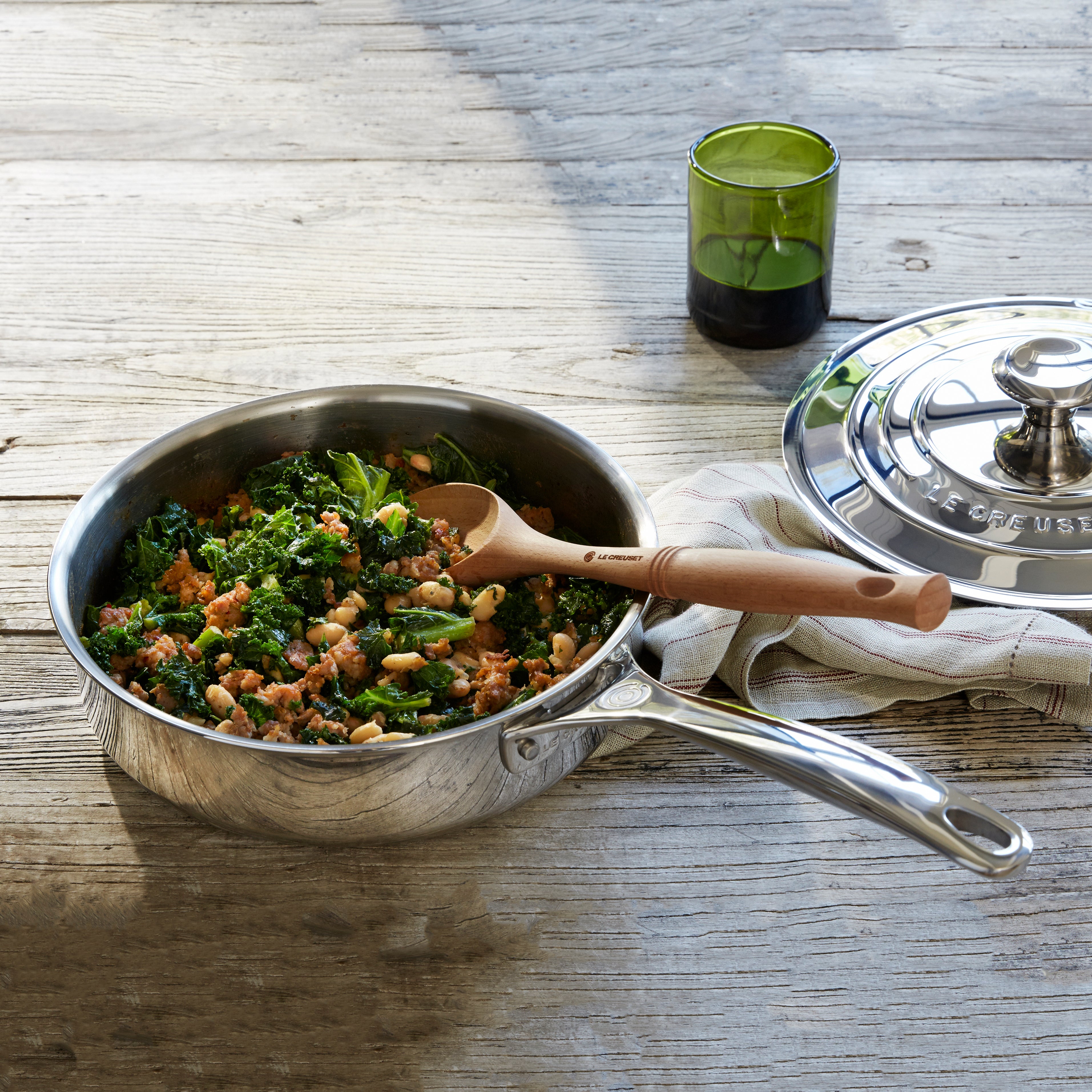 Close-up of the precision-pour rim and stay-cool handle of the Le Creuset stainless steel sauté pan.