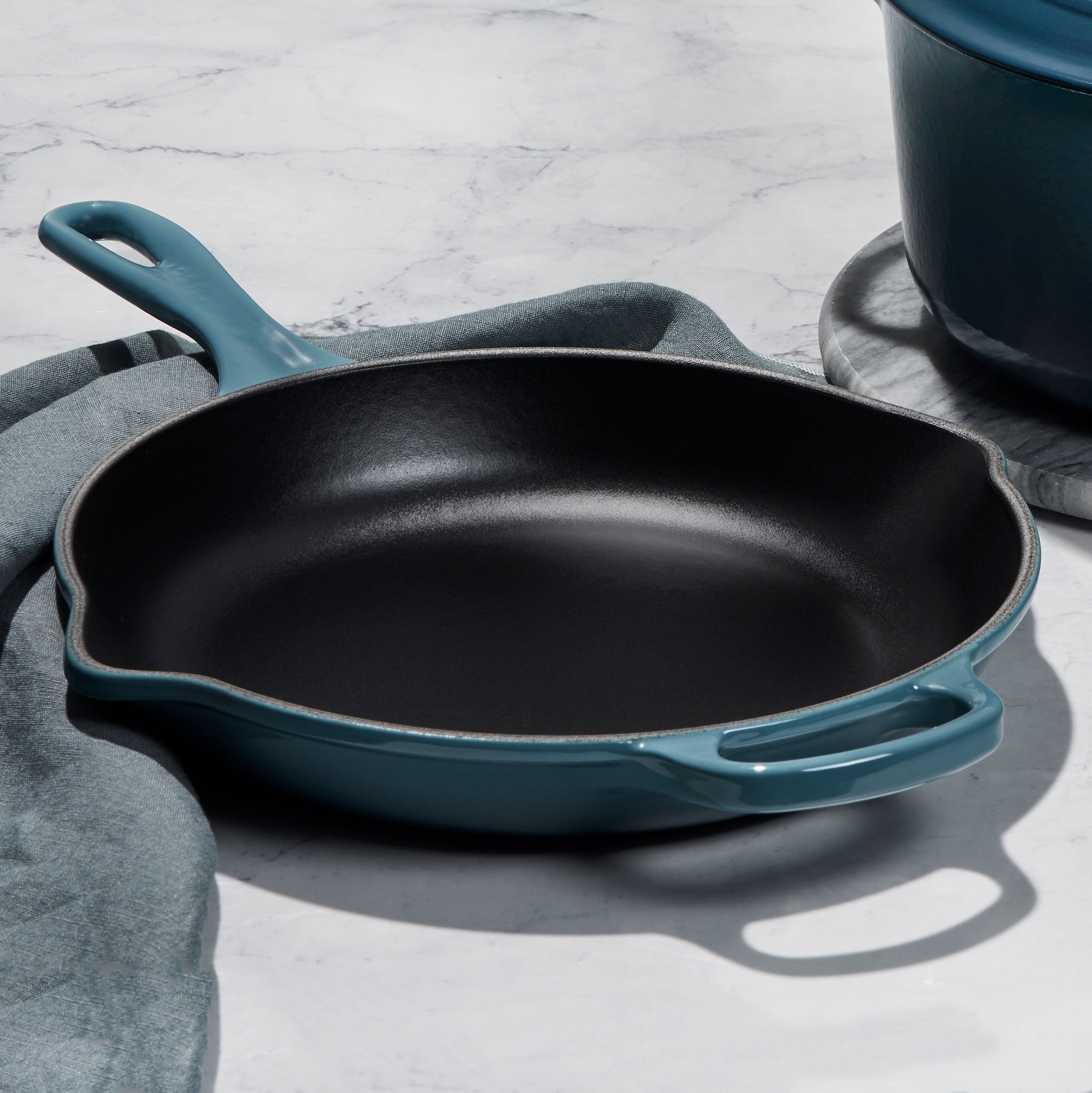 Side angle of cooking set showing ergonomic wide-loop handles and stainless steel knobs