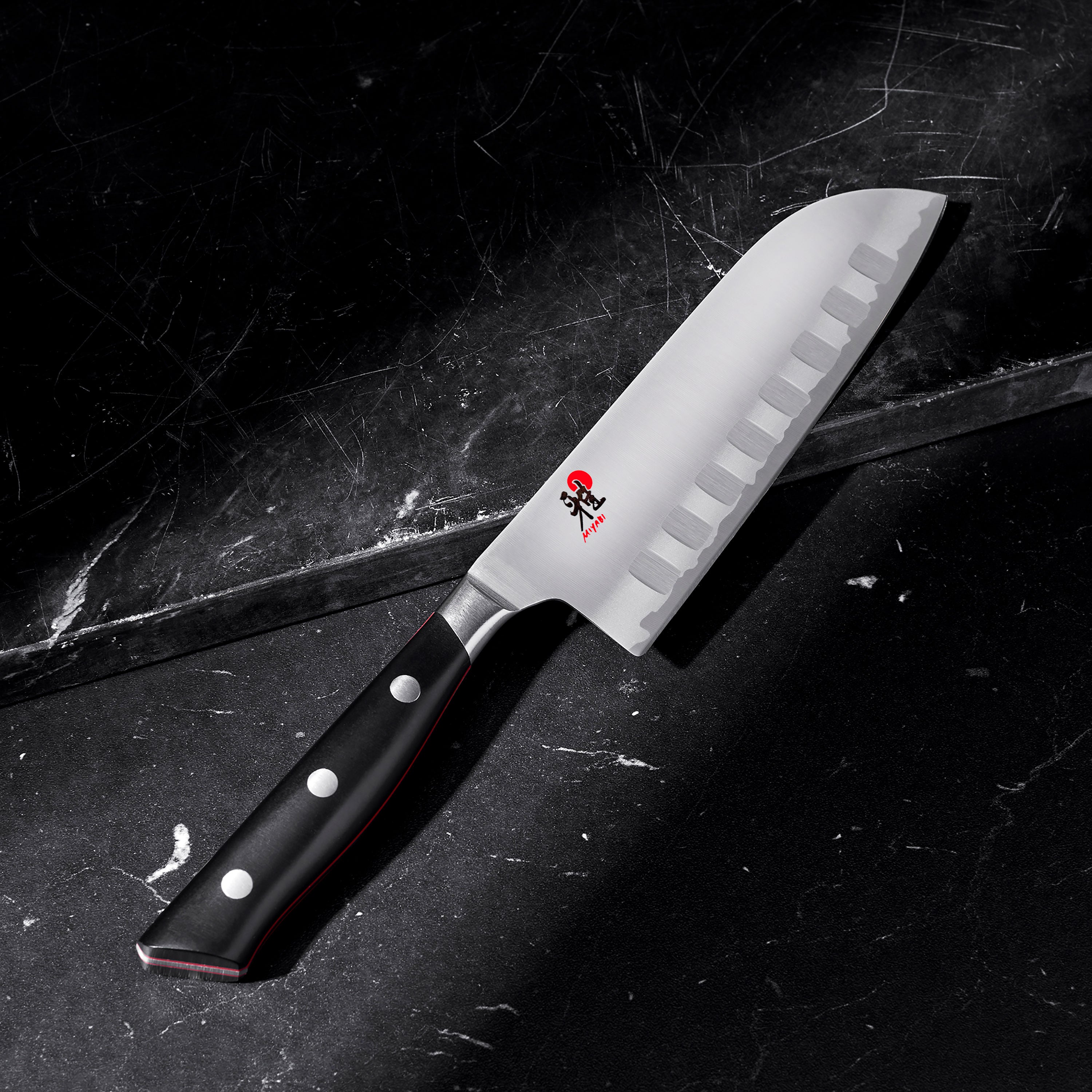 Miyabi Evolution Santoku knife in action, slicing vegetables on a cutting board, highlighting its performance.