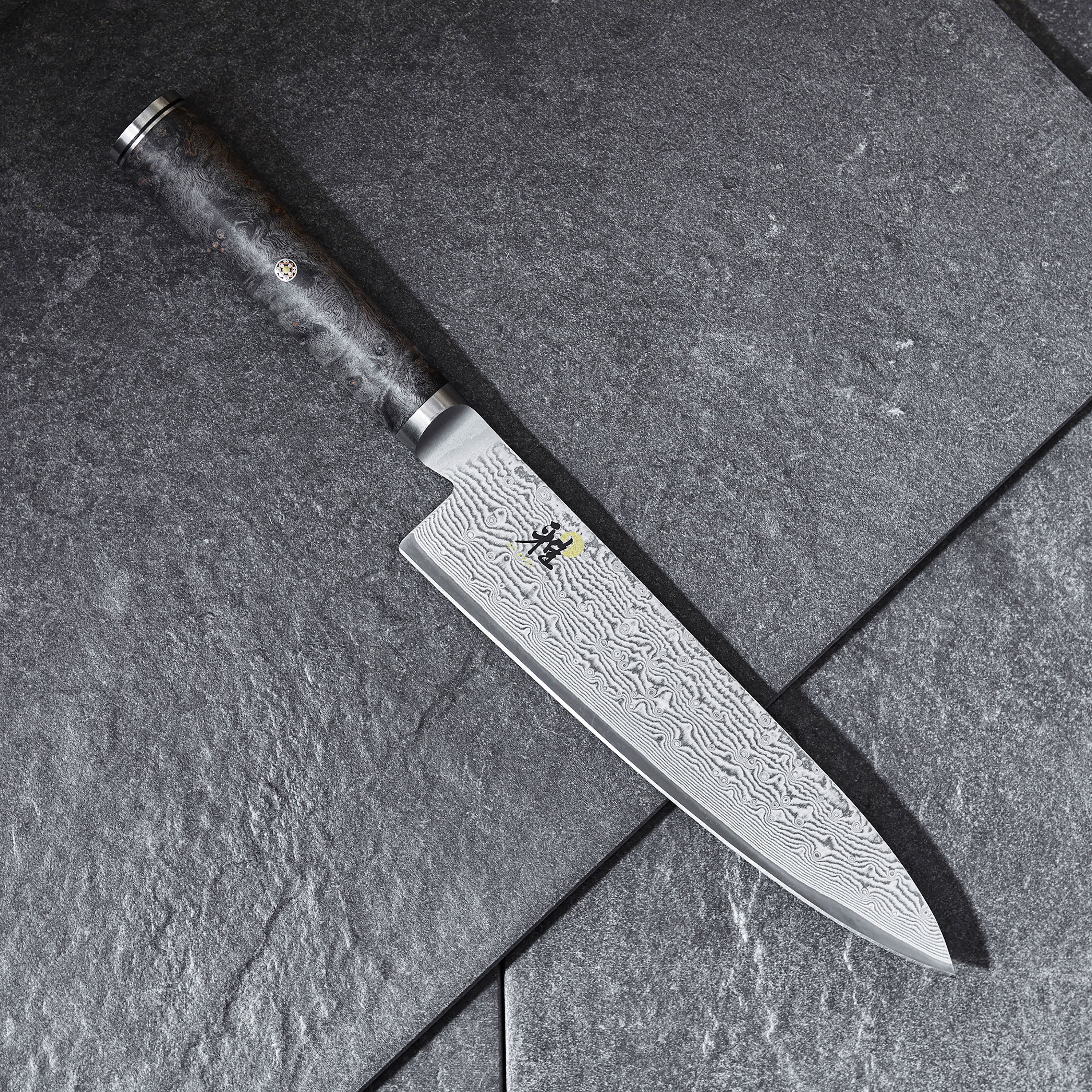 D-shaped handle of the Miyabi Black knife set, emphasizing the exquisite Bigleaf maple material.