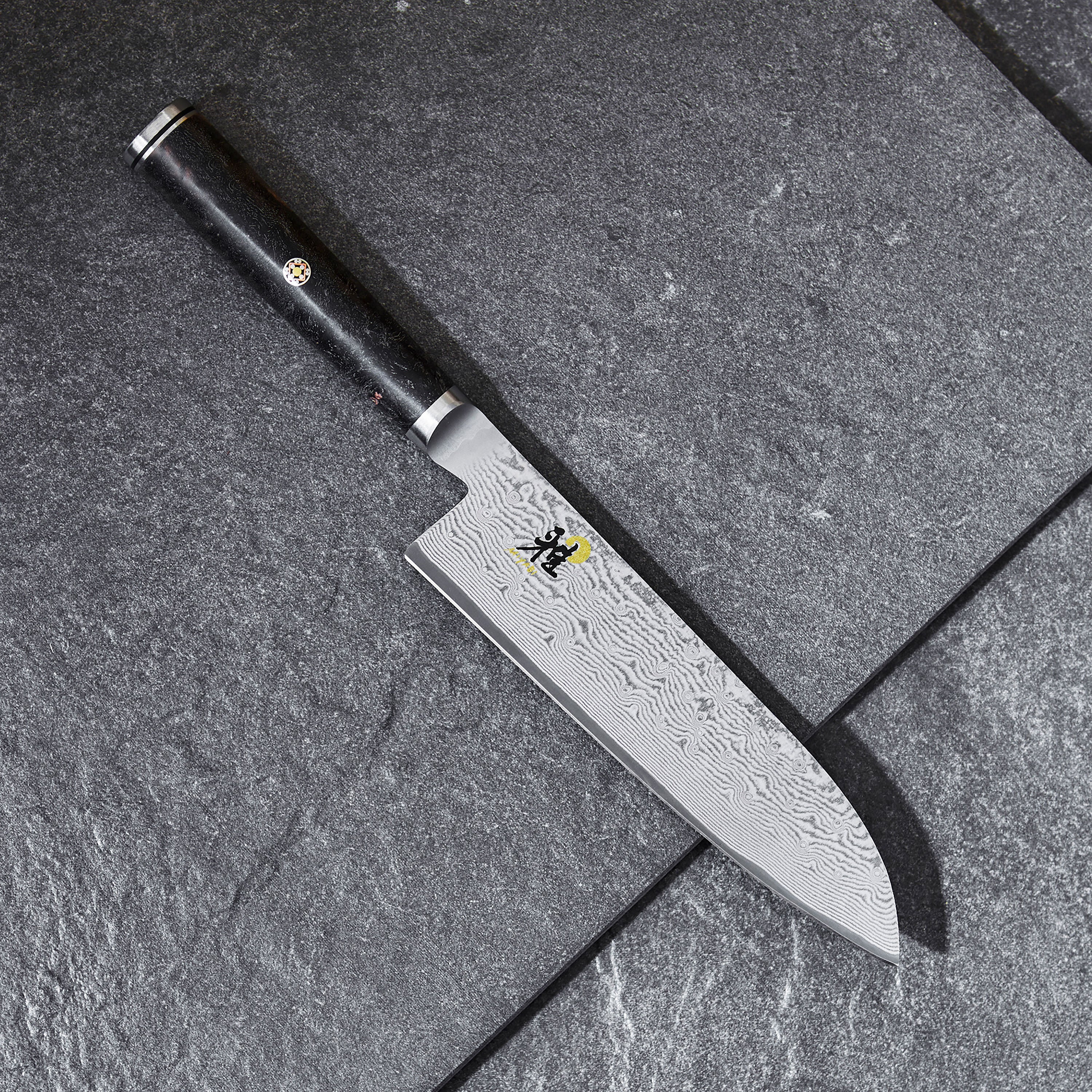 Detailed view of the D-shaped handle of the Miyabi Black Santoku Knife.
