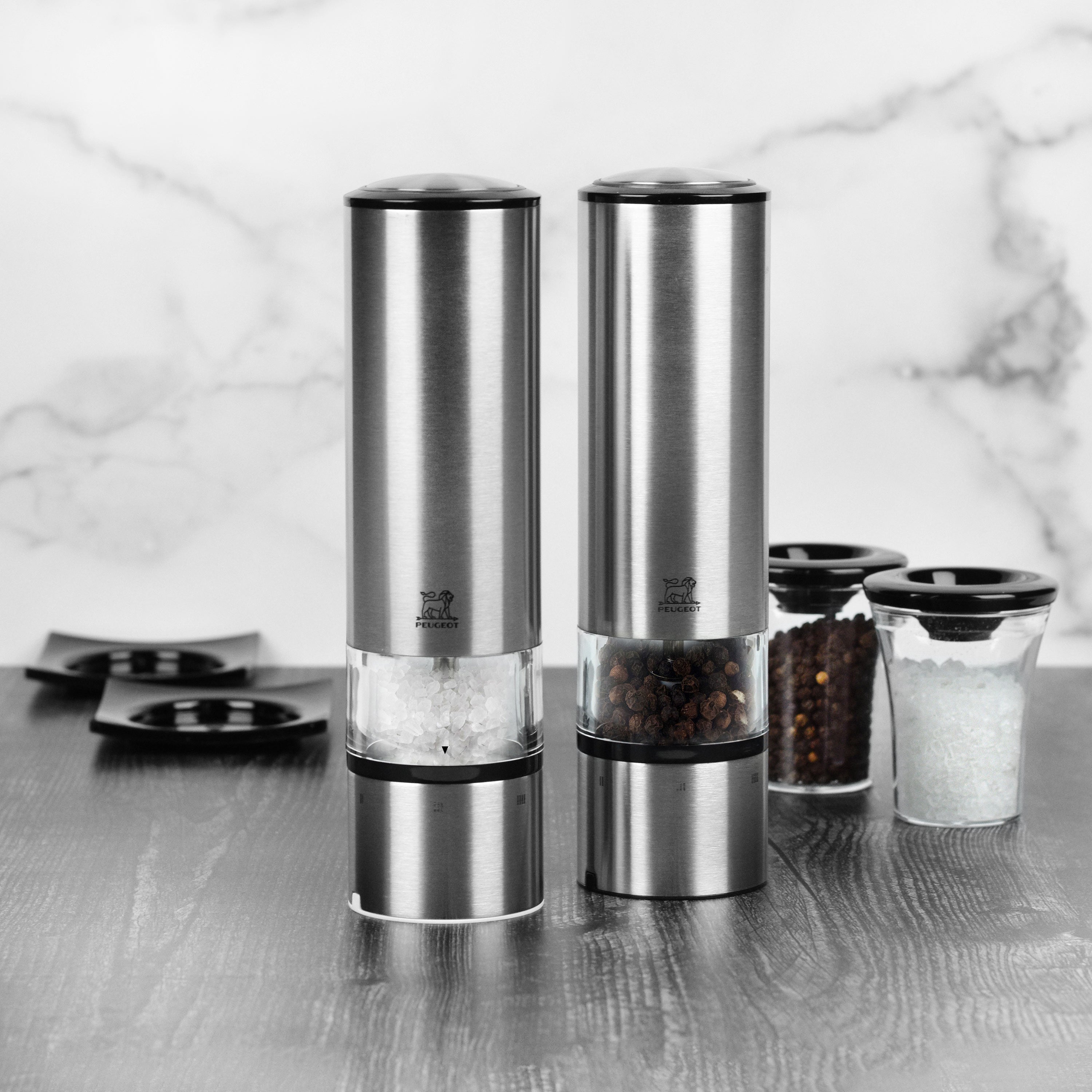Close-up of Peugeot Elis Sense stainless steel electric salt and pepper mill with LED light in use