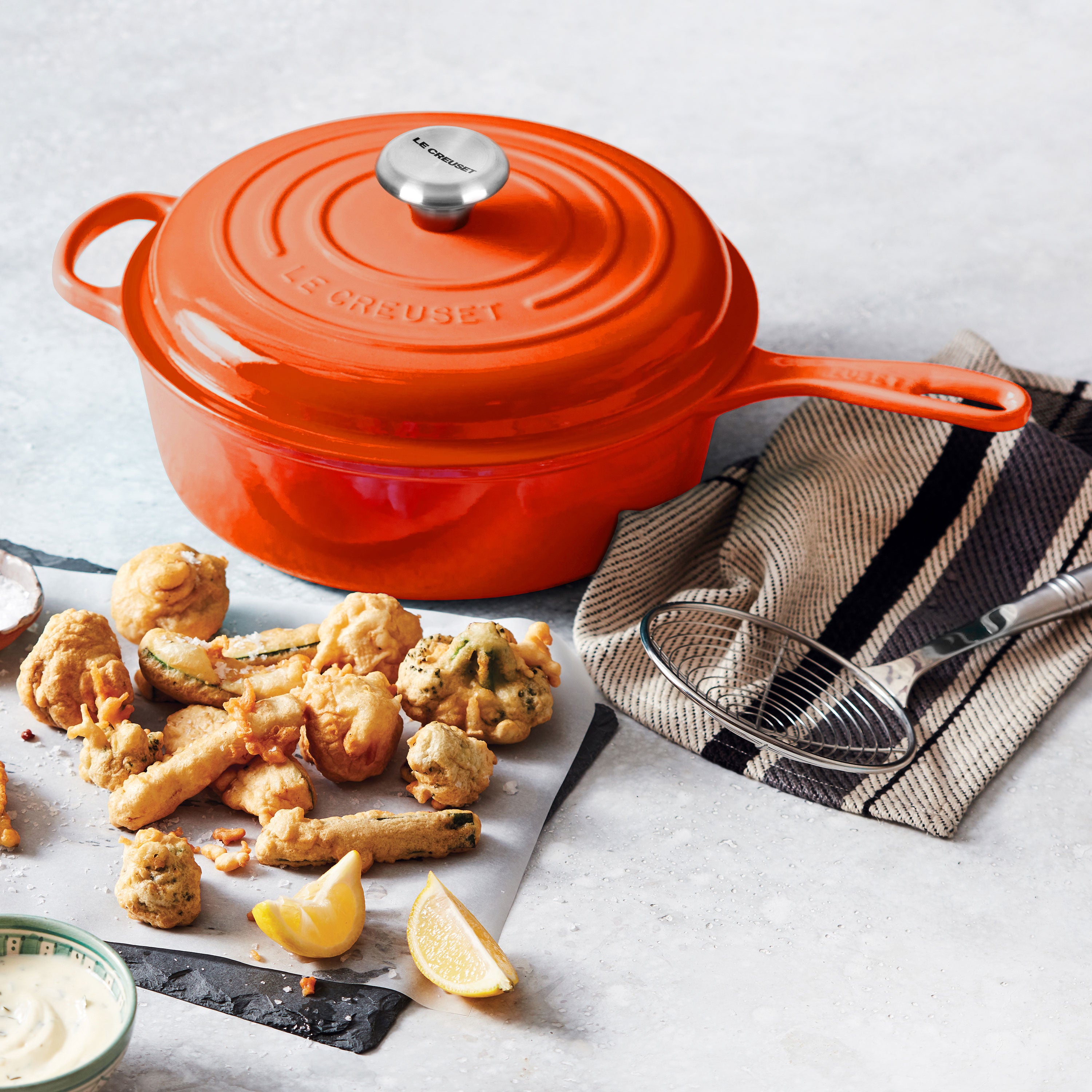Le Creuset 3.75-quart cast iron Dutch oven with lid on stove top, flame color