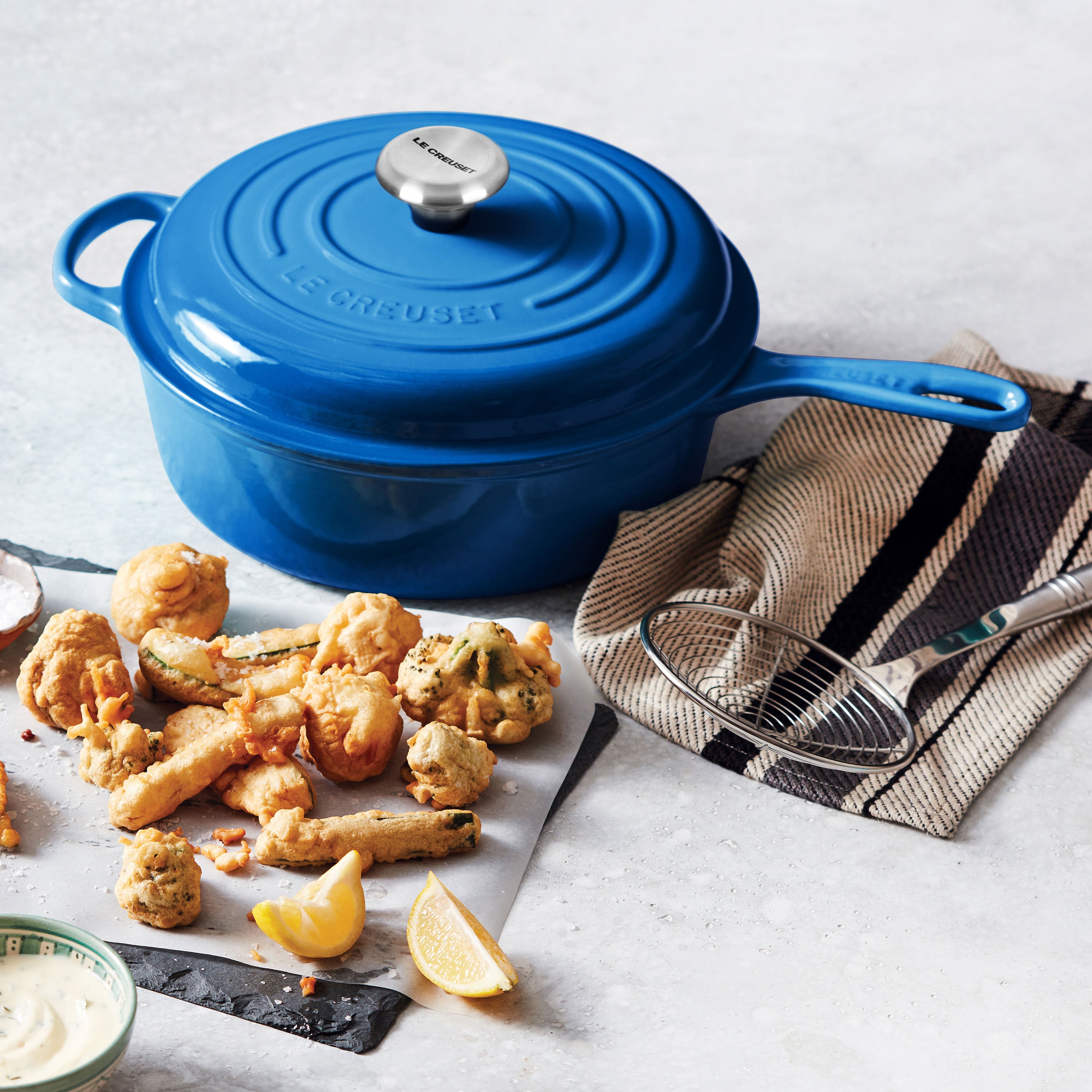 Le Creuset Marseille 3.75-quart enamel cast iron pot with lid, angled view, showcasing its sturdy handle.