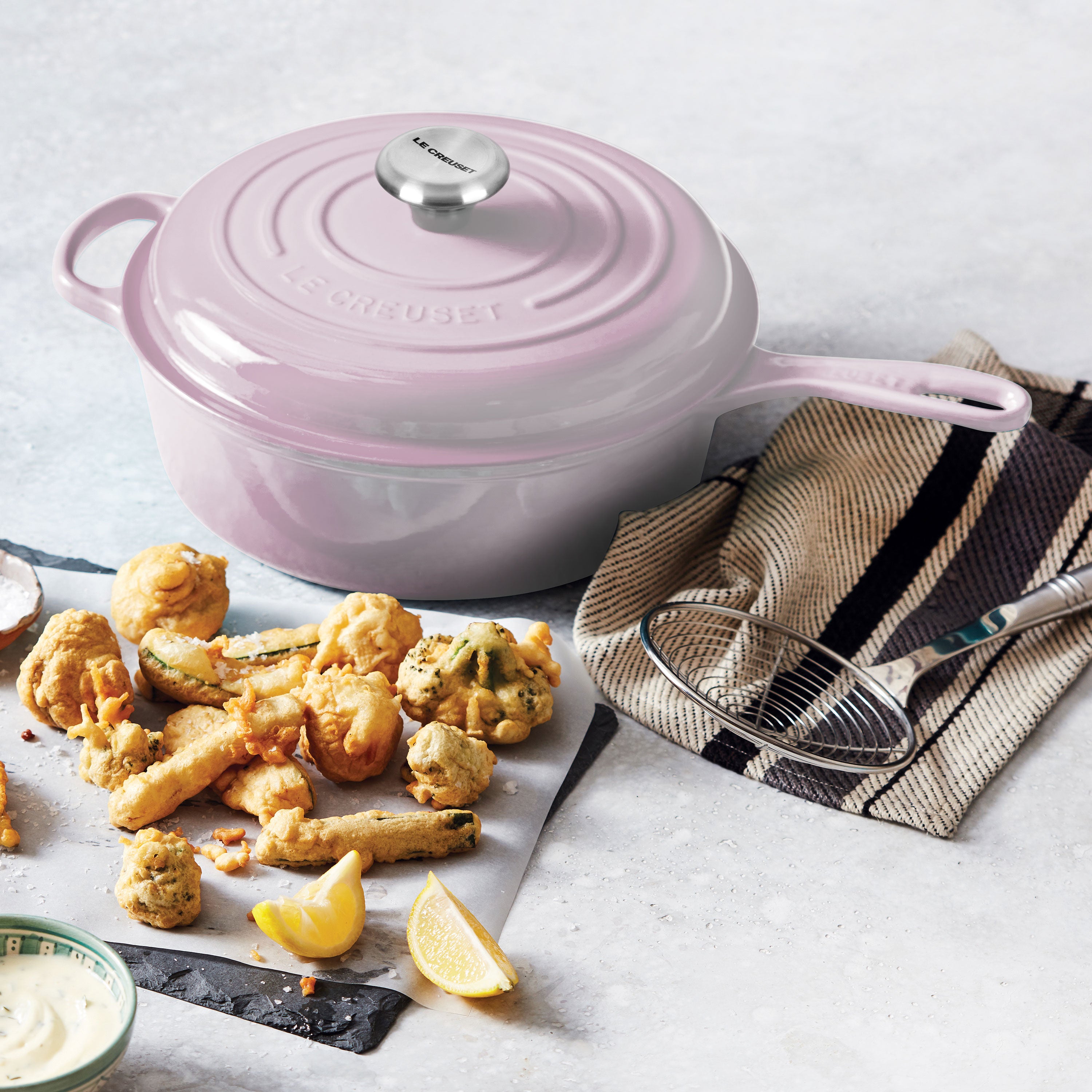 Close-up of the ergonomic handle on the Le Creuset cast iron cooking pot with lid.