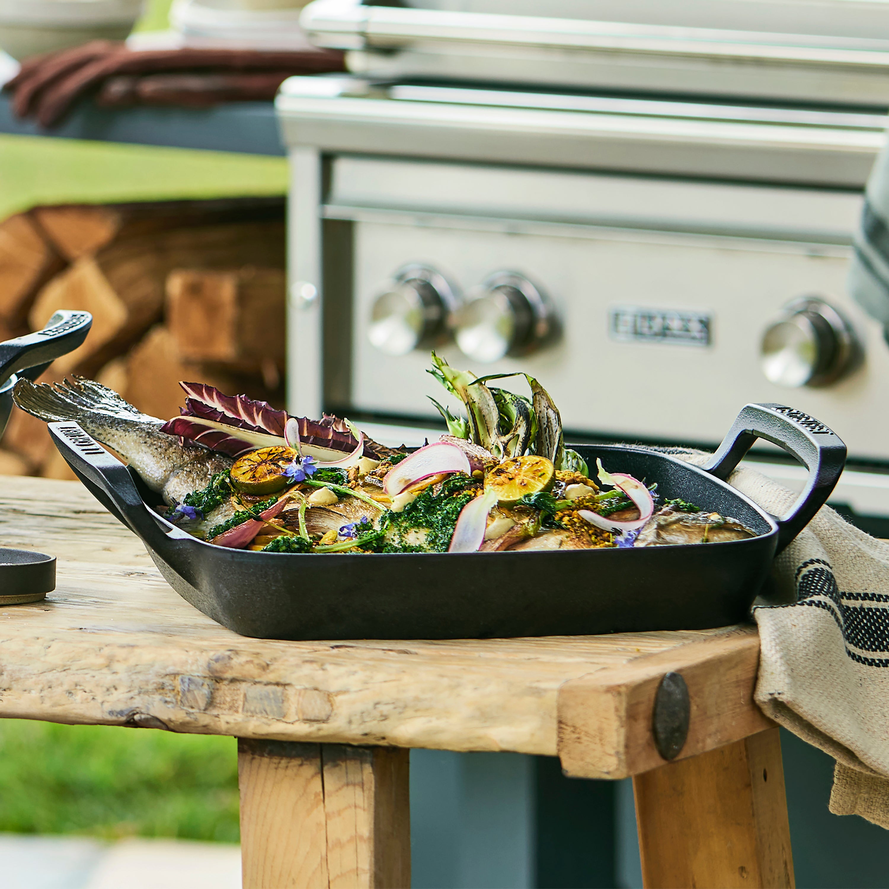 Le Creuset 12-inch cast iron grill basket with food on grill