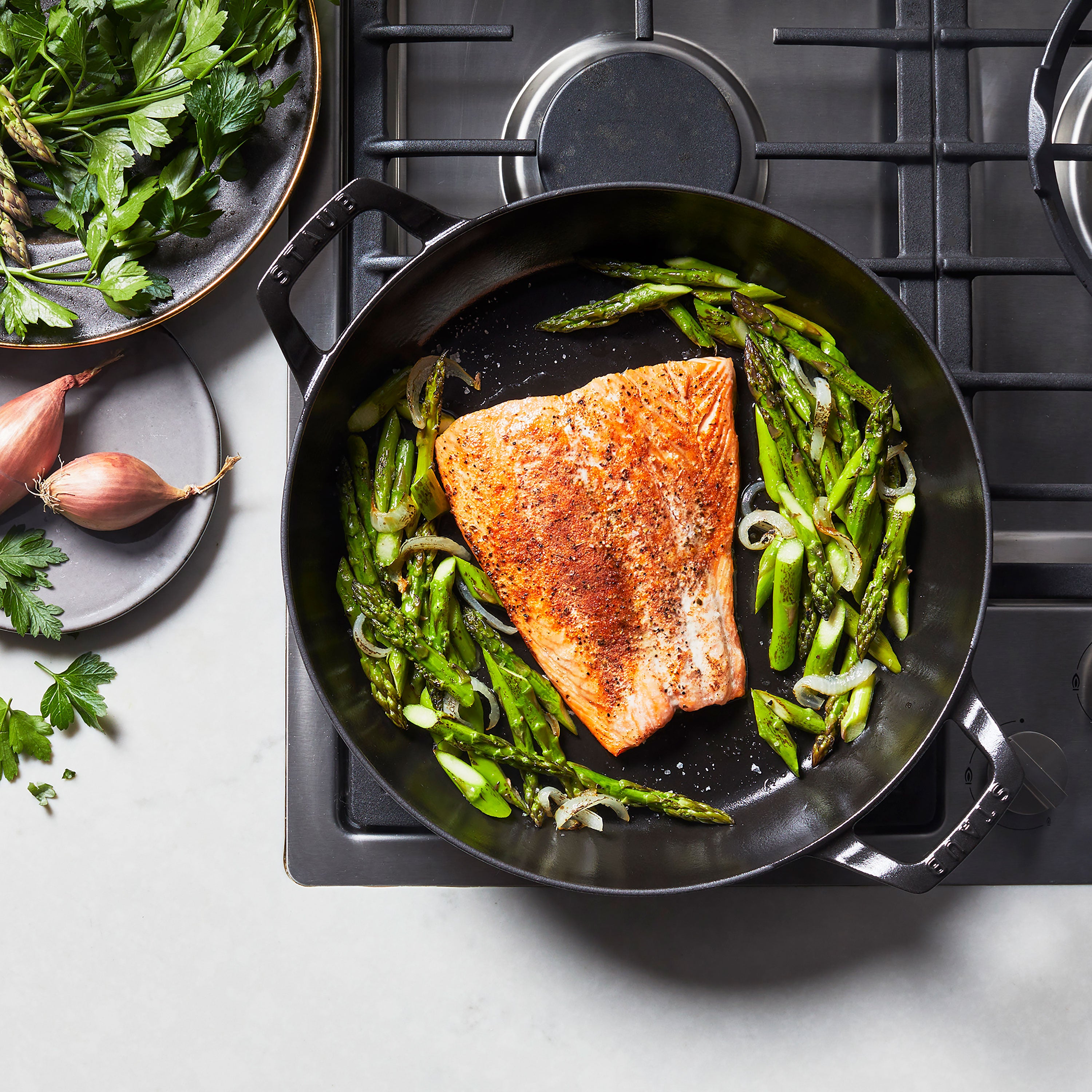 Staub enameled cookware in use, simmering a hearty stew on the stove.