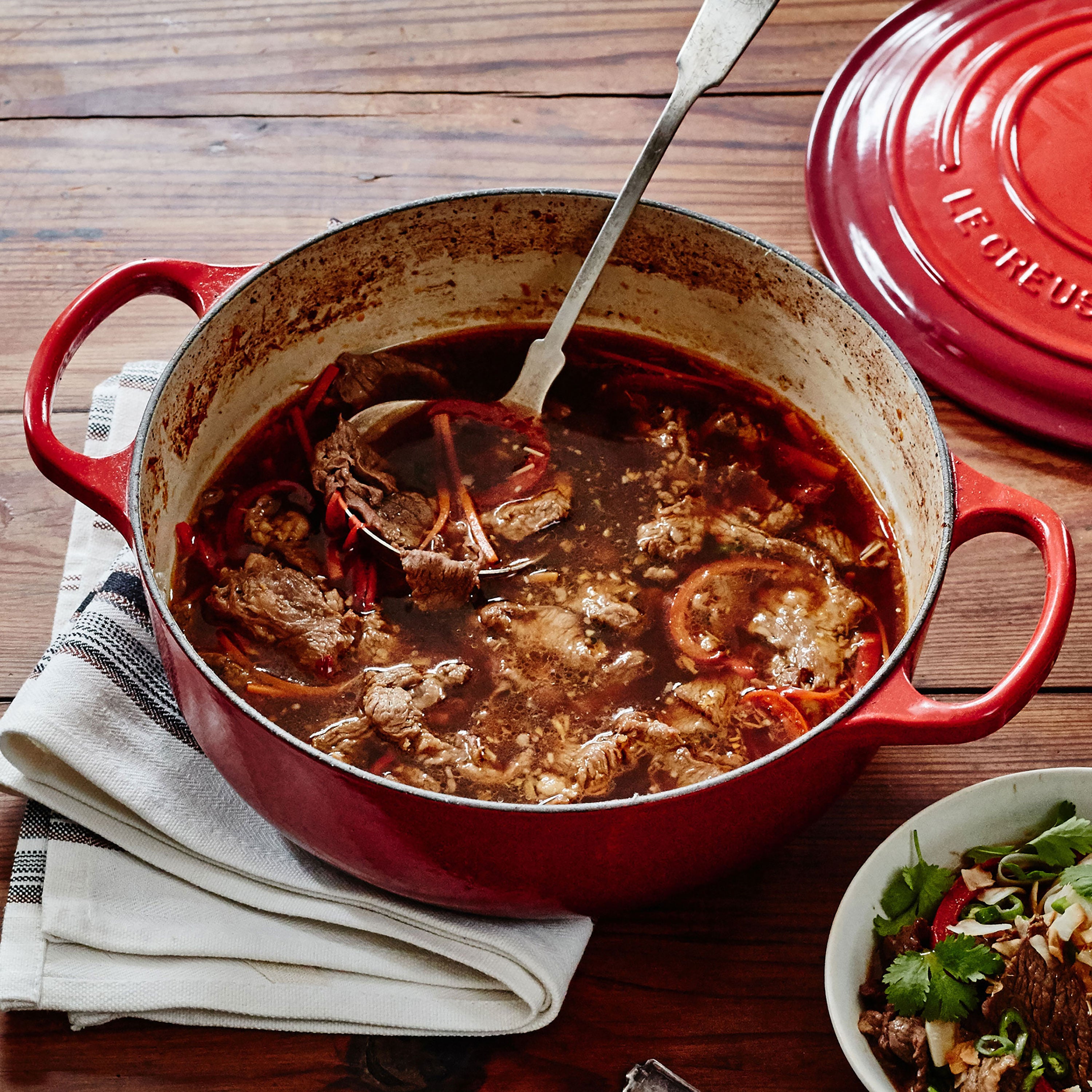 Top-down view of Cerise Le Creuset 3.5-quart Dutch oven with lid on stovetop