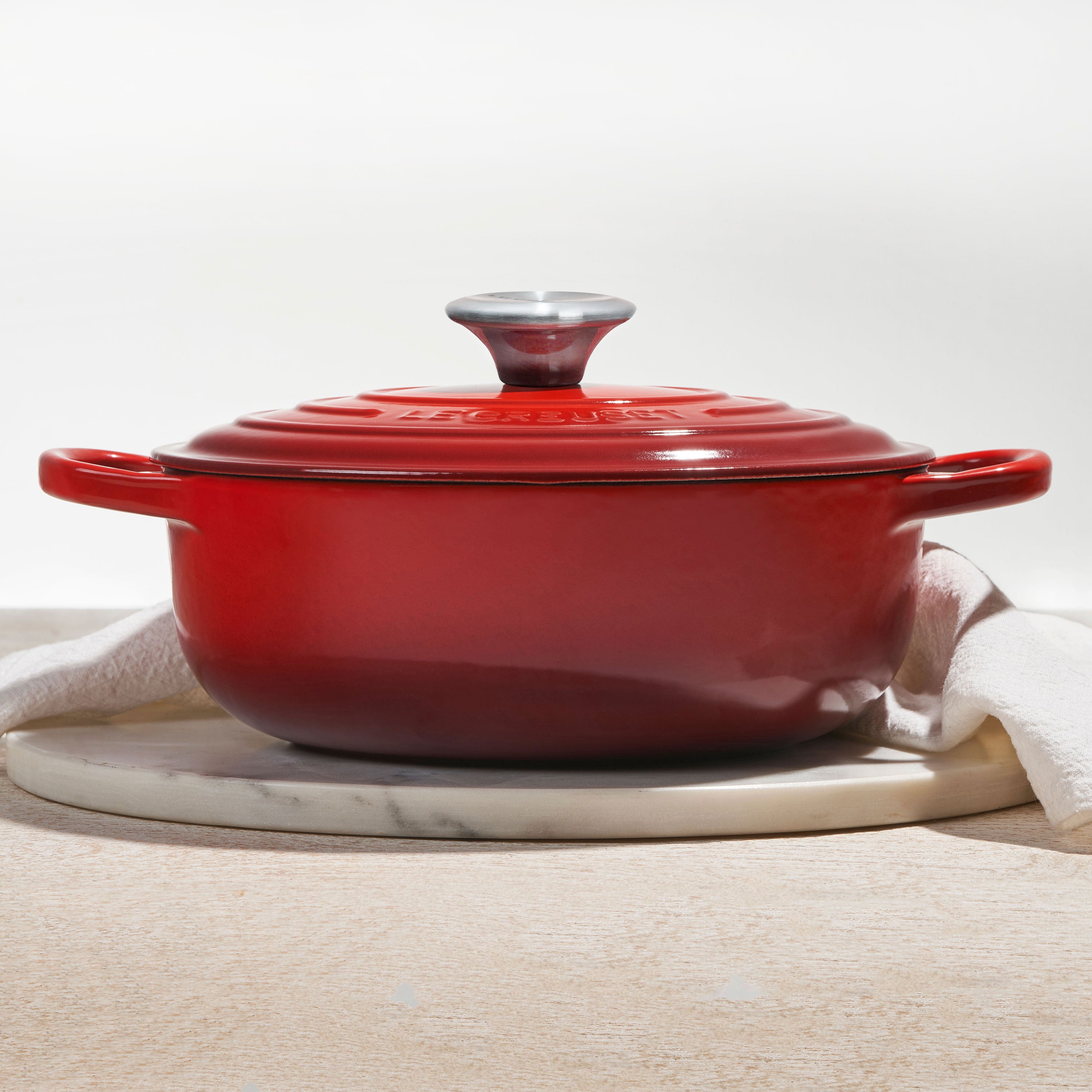 Top-down view of Cerise Le Creuset 3.5-quart Dutch oven with lid on stovetop