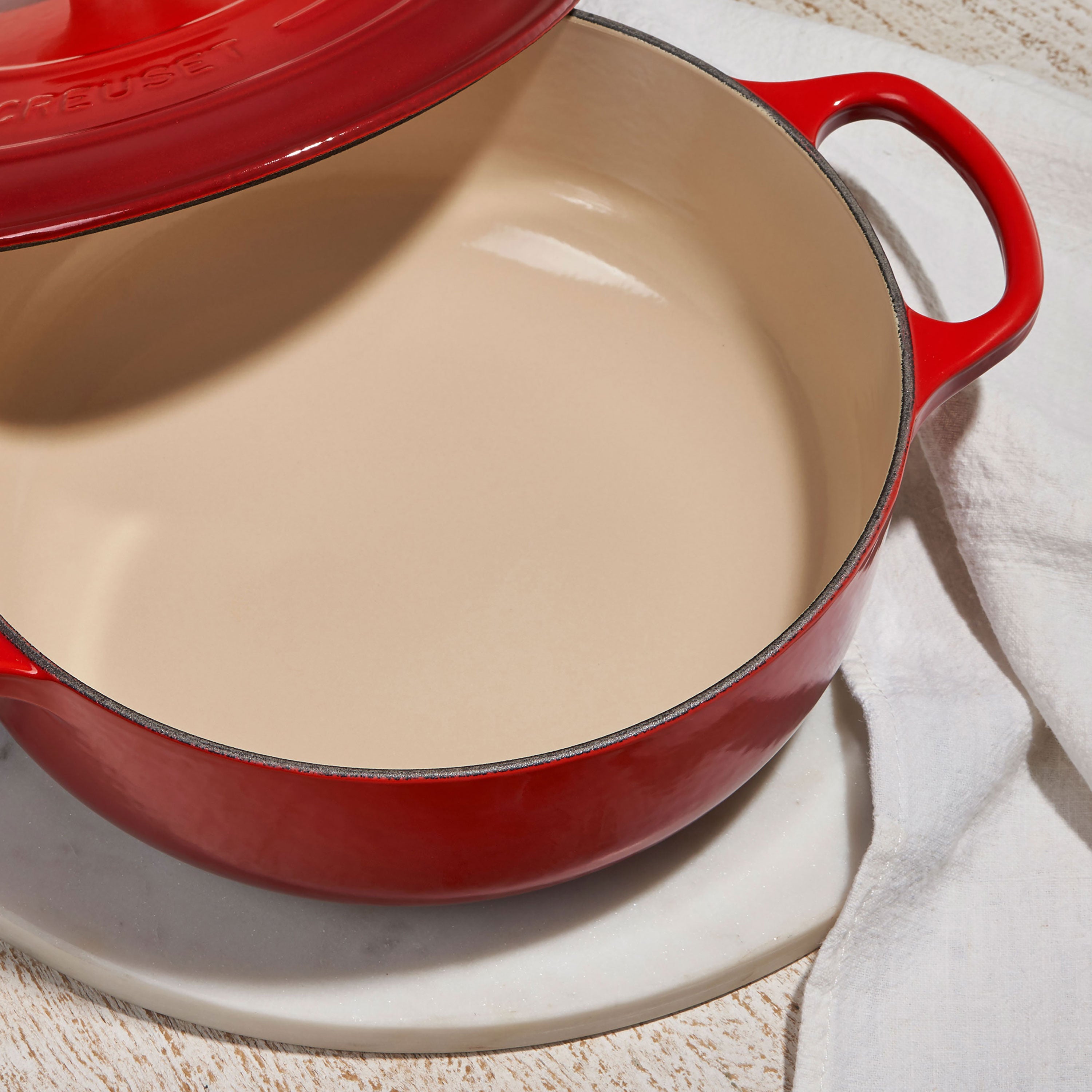 Tabletop setting showcasing Le Creuset cookware with a finished braise inside the Dutch oven