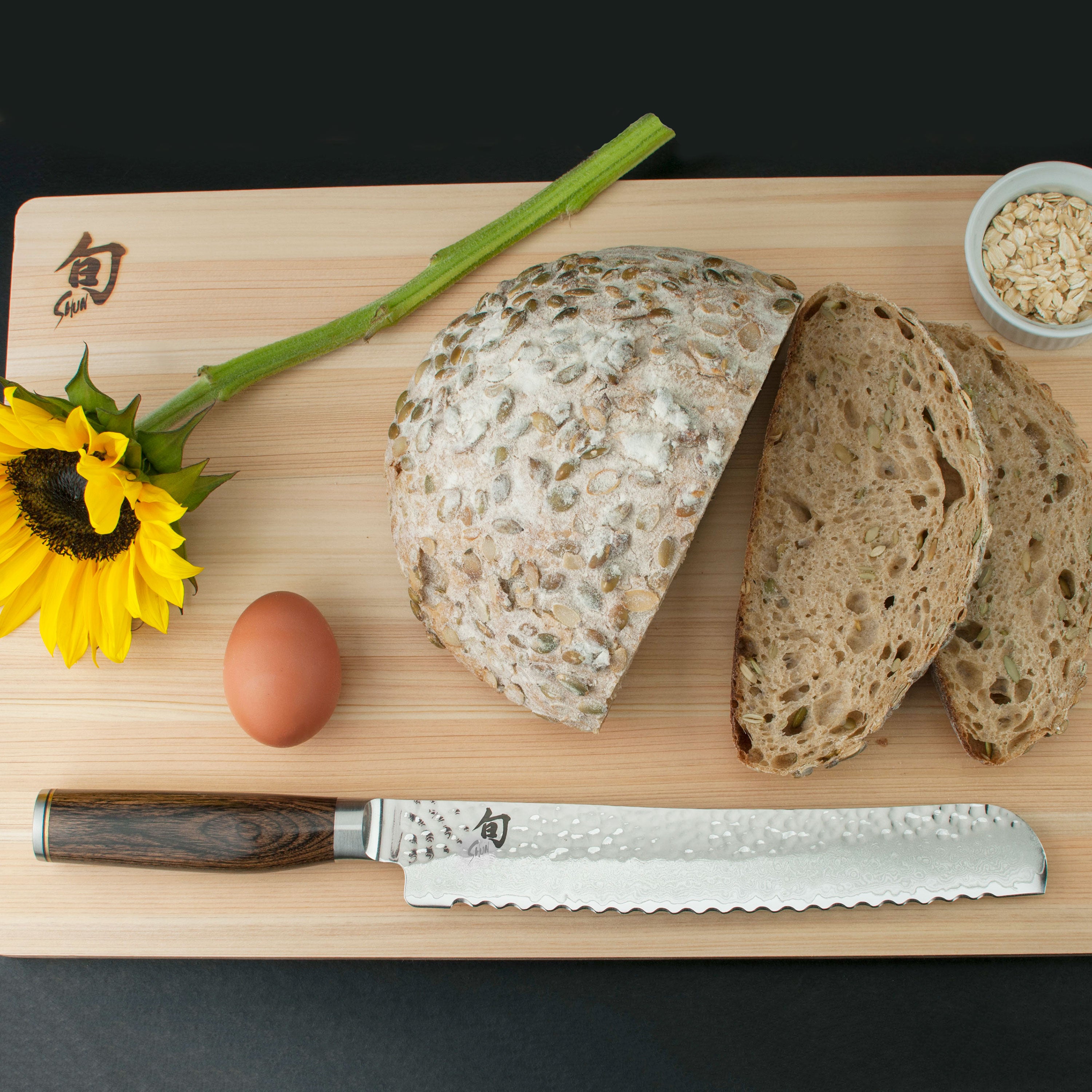 Shun Premier bread knife displayed on a wooden cutting board with bread.