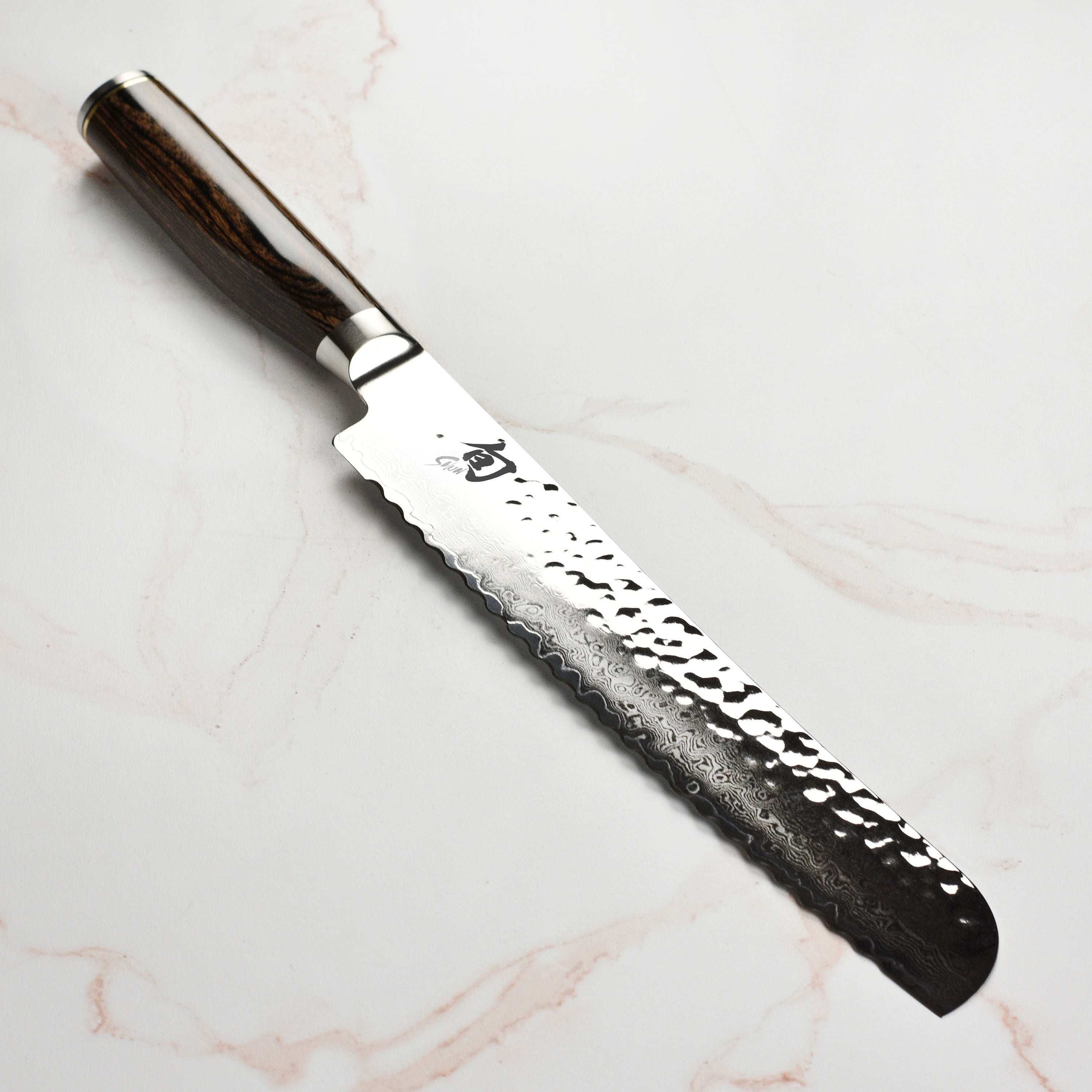 Shun Premier 9-Inch Damascus Bread Knife showcasing the blade and handle design.