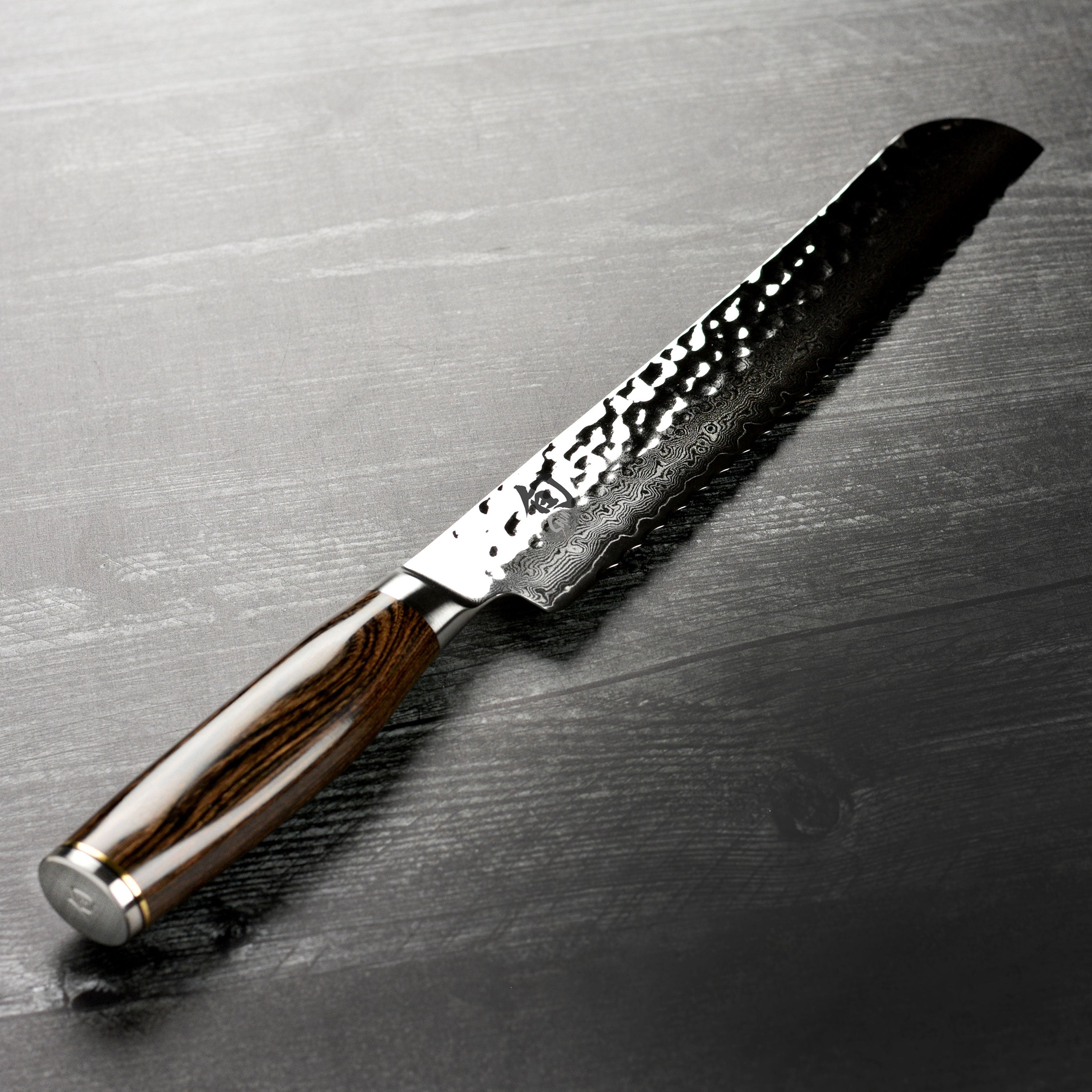 Close-up of the Shun Premier knife slicing through freshly baked bread.
