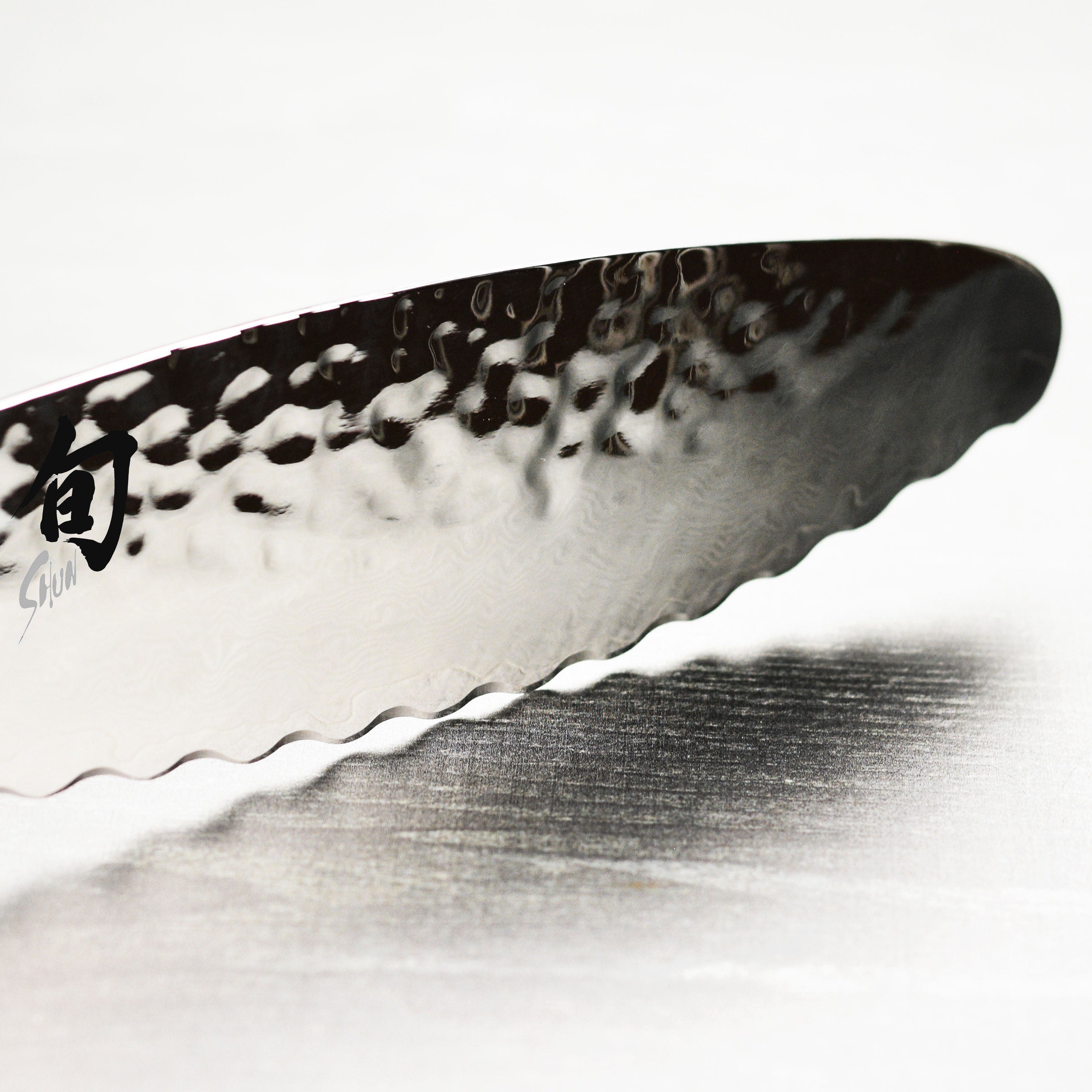 Shun Premier 6 inch utility knife on cutting board with vegetables, showcasing hammered Tsuchime finish
