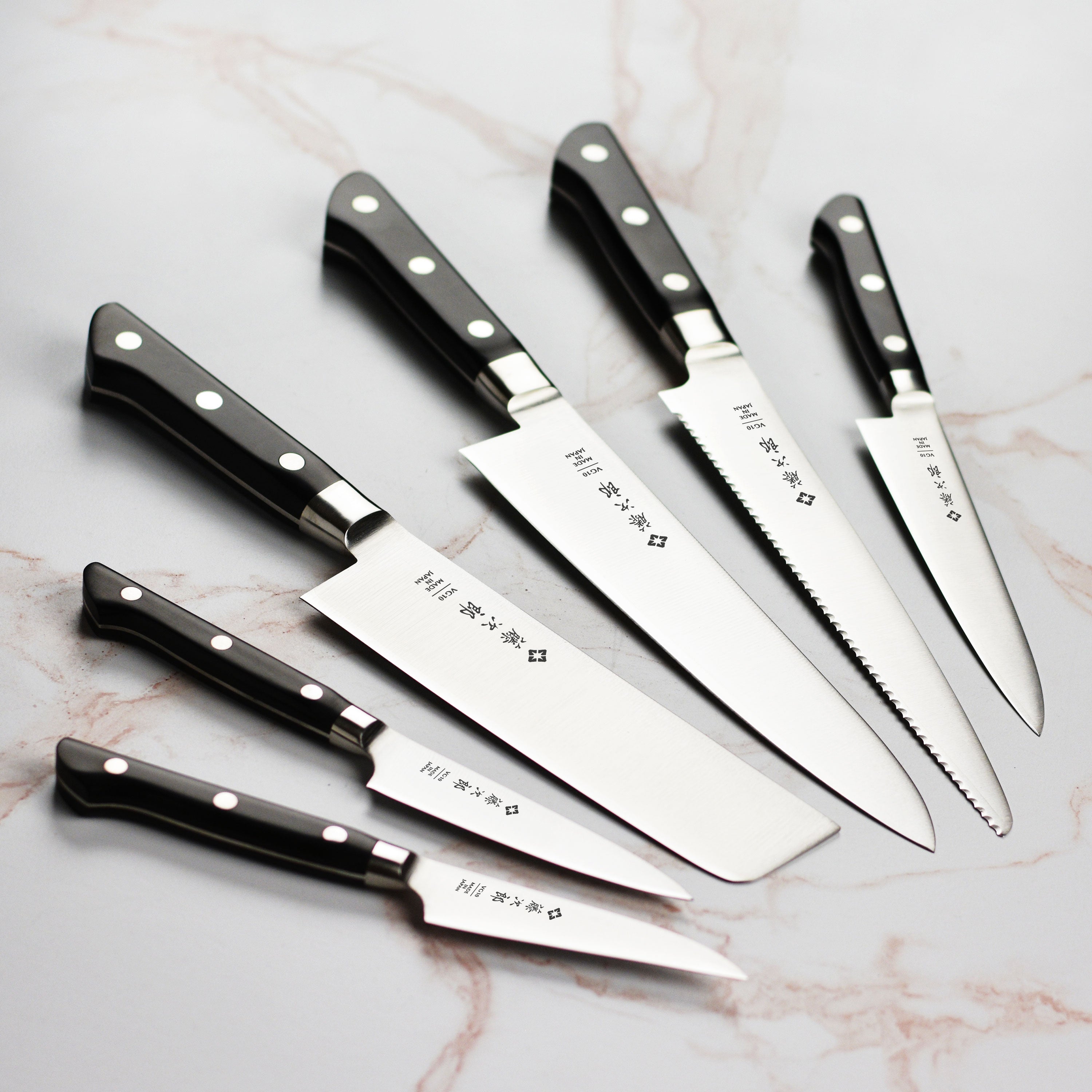Close-up of the VG-10 blade of the Tojiro kitchen knife, highlighting its sharpness and design.
