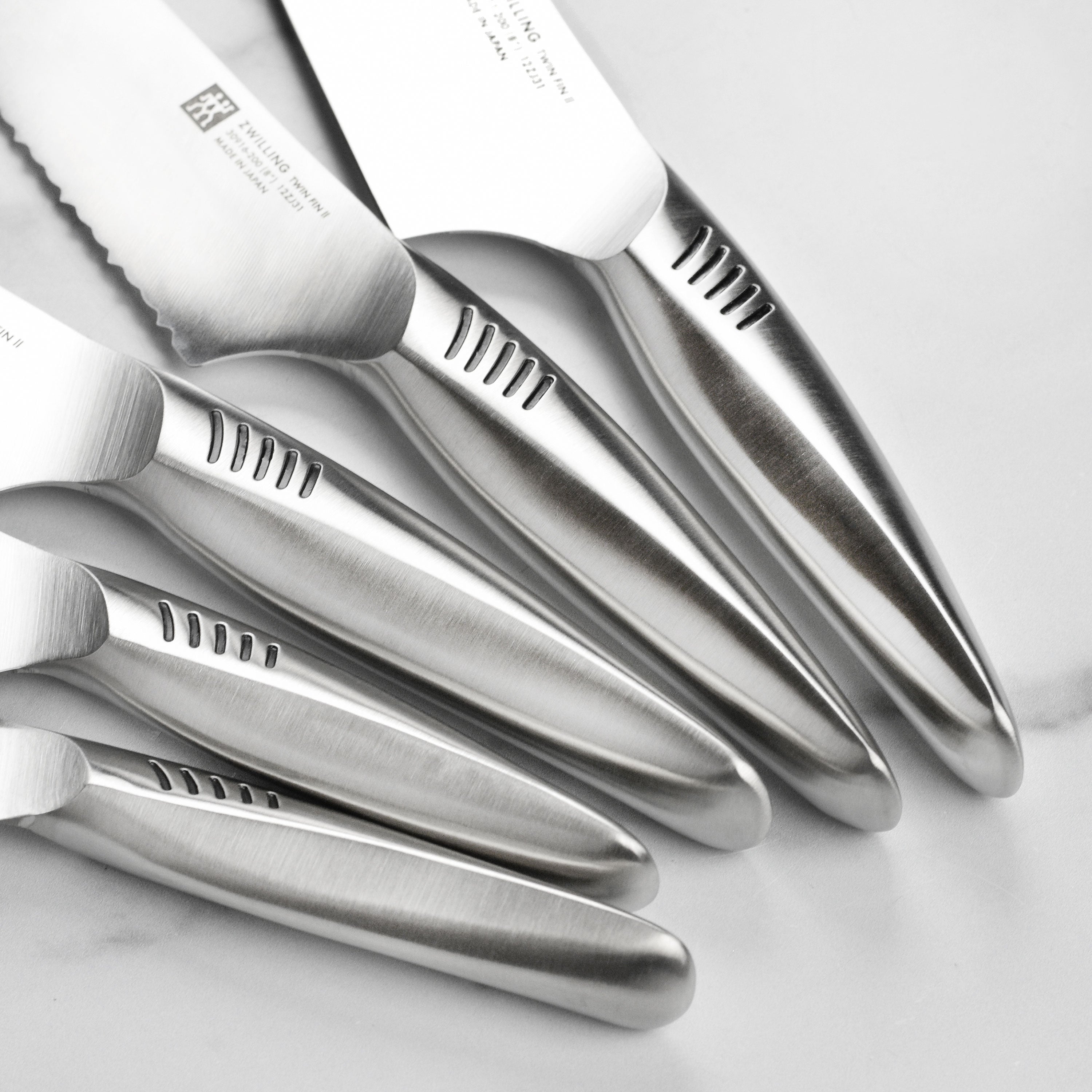 Japanese chef knife set with bamboo handles and stainless steel blades on a cutting board