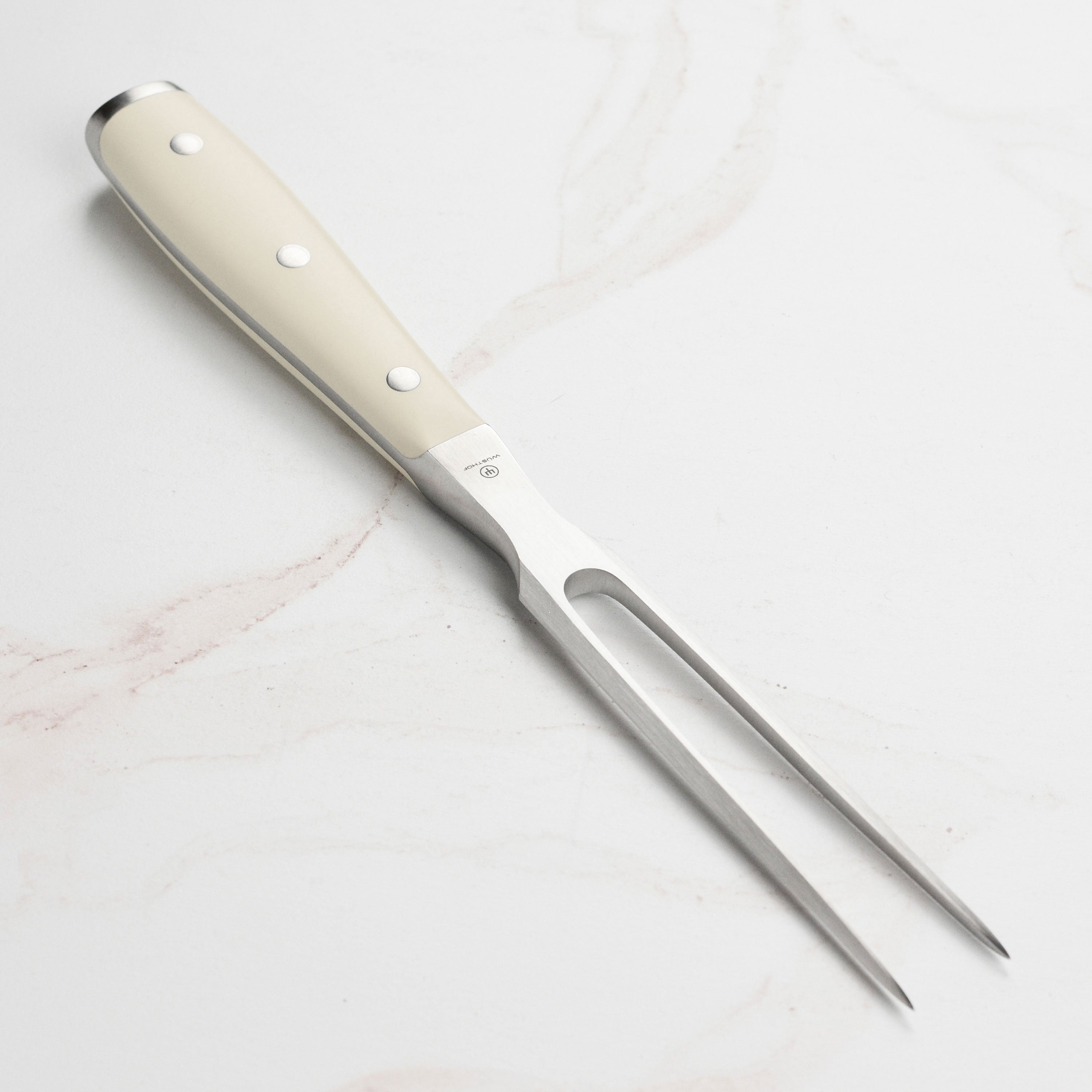 Side view of Wusthof Classic Ikon Creme carving fork next to roast beef