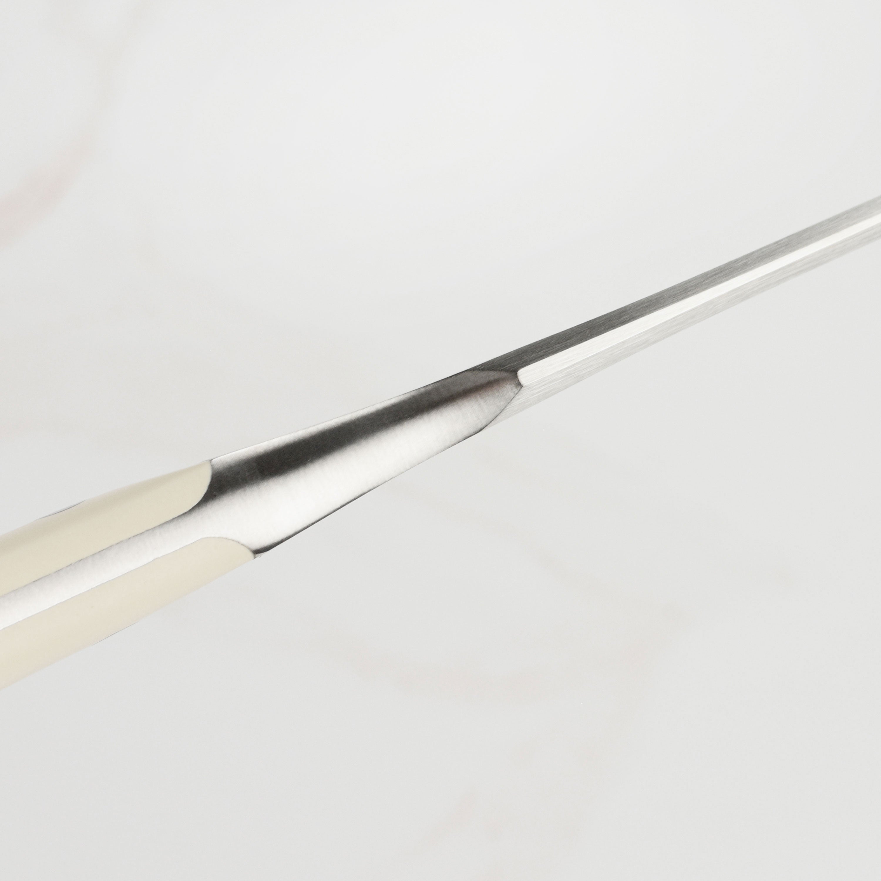 Kitchen fork with creme handle displayed on countertop with cutting board