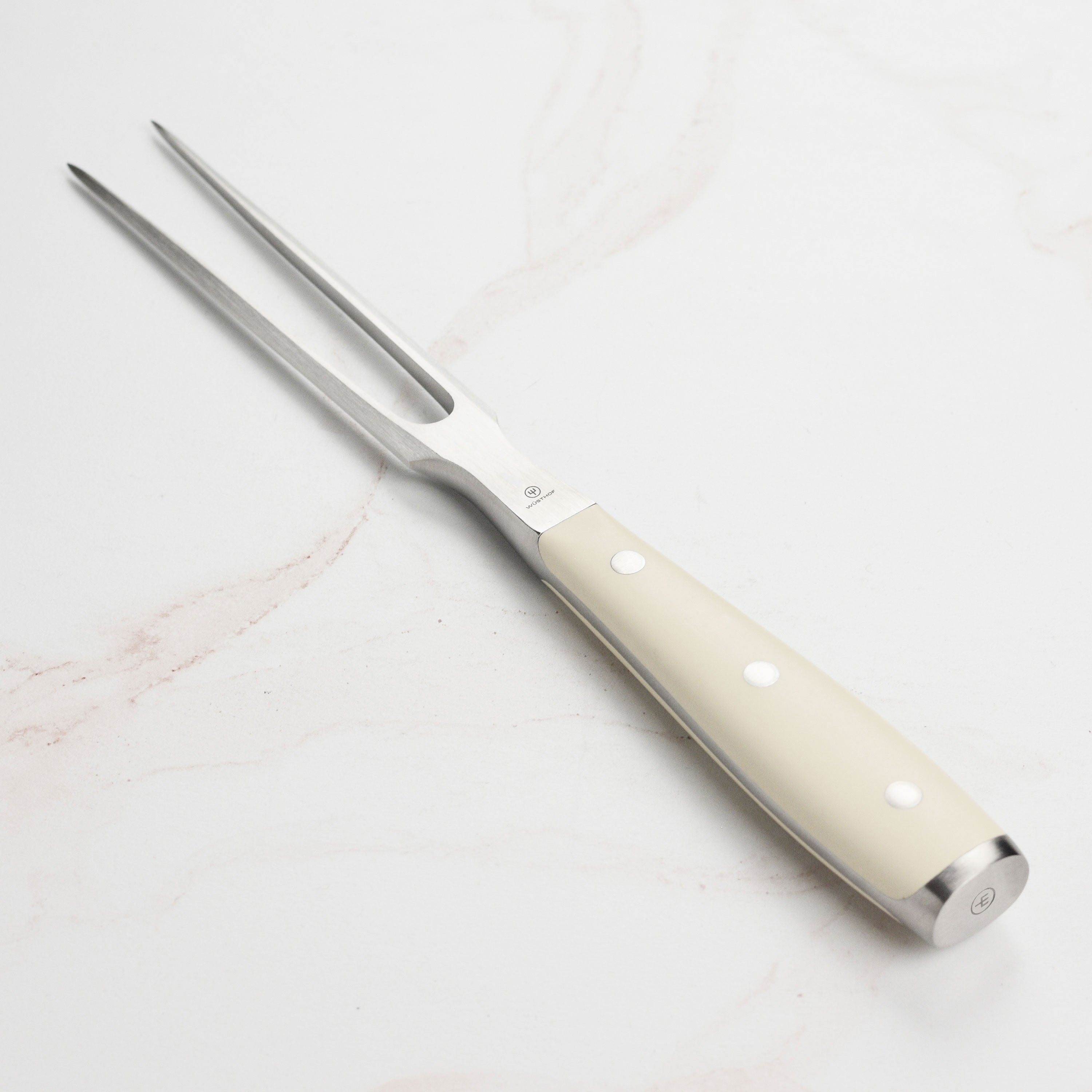 Kitchen fork with creme handle displayed on countertop with cutting board