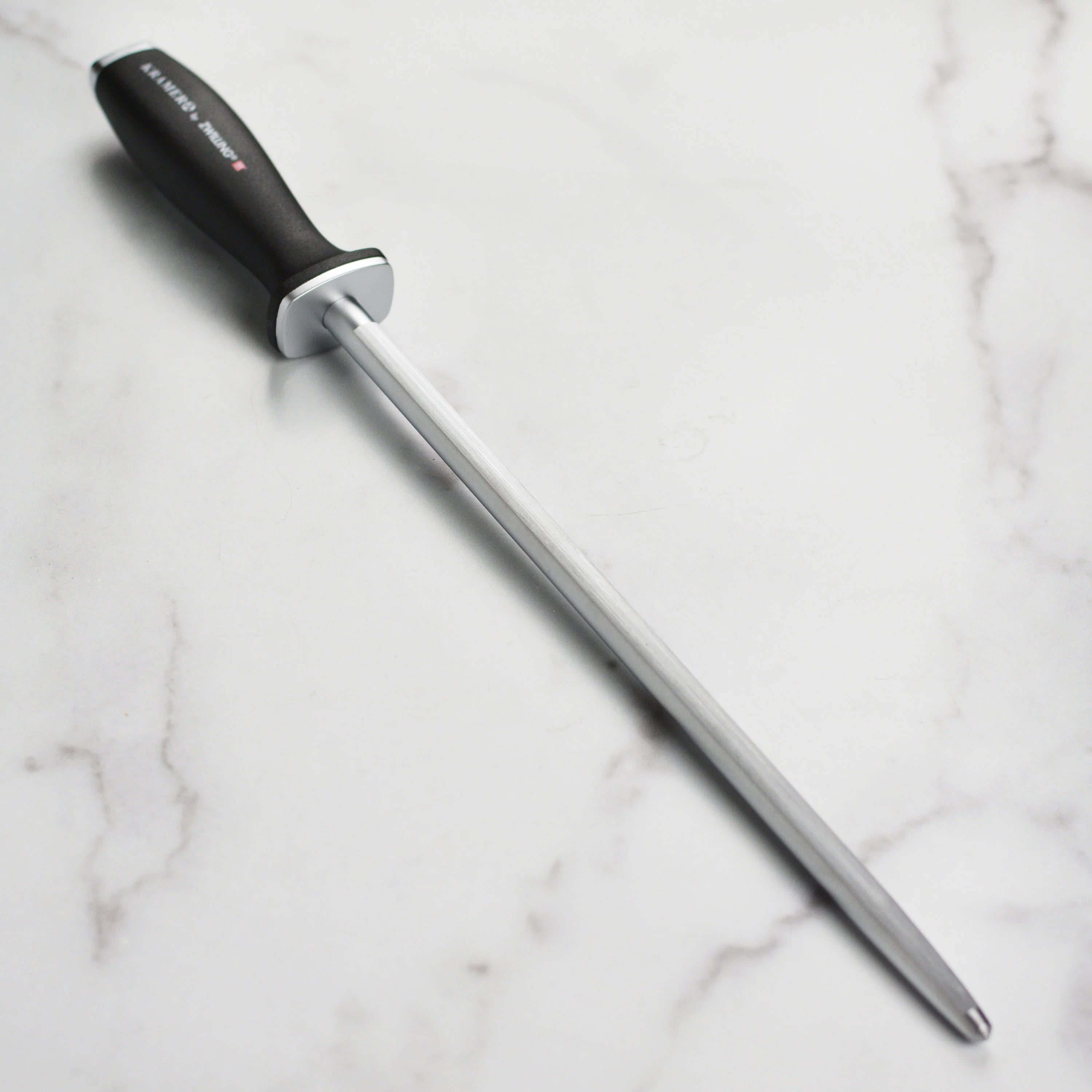 Chef using Kramer Cumulus knife for precision slicing in a modern kitchen