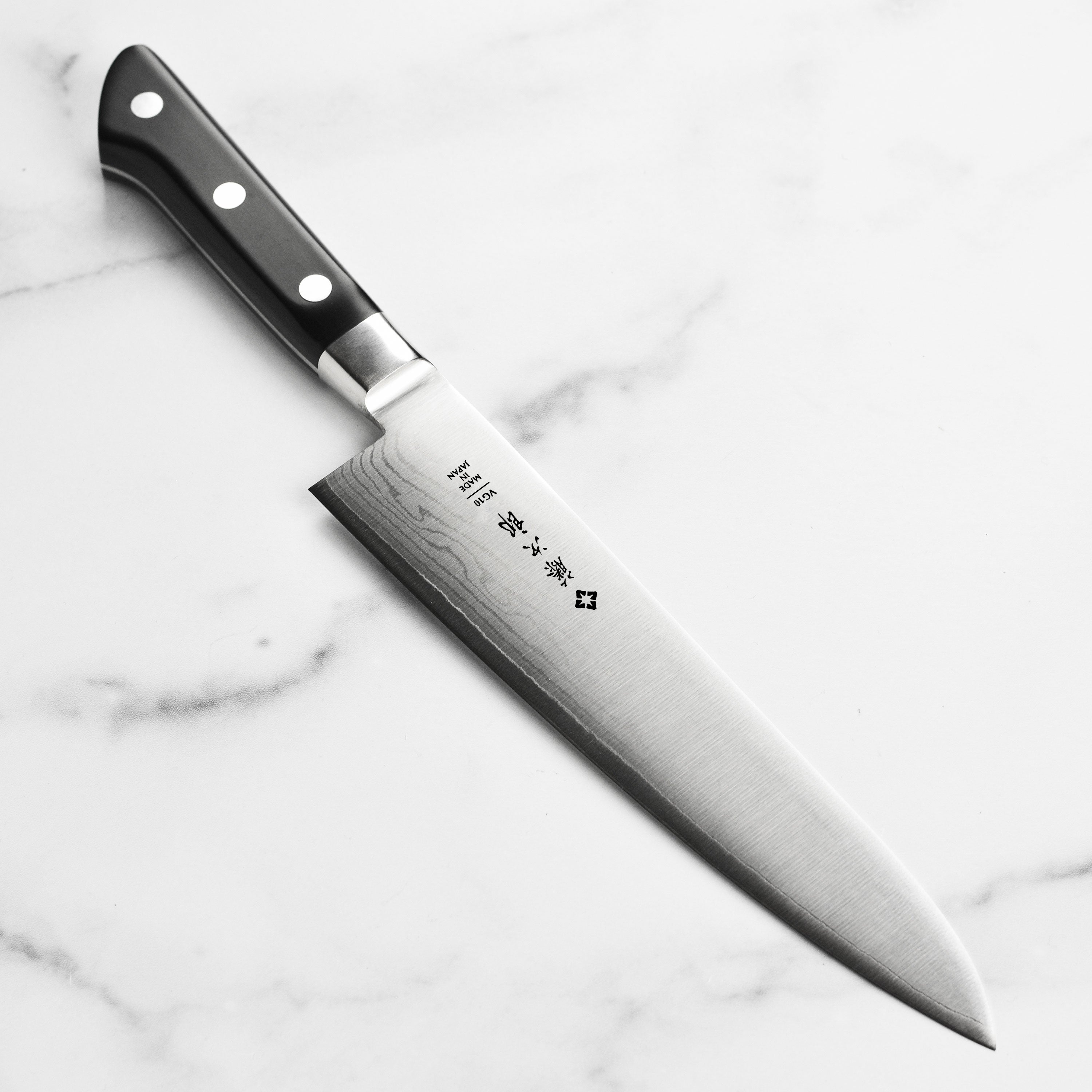 Side view of Japanese knife showing Damascus pattern and VG10 steel finish
