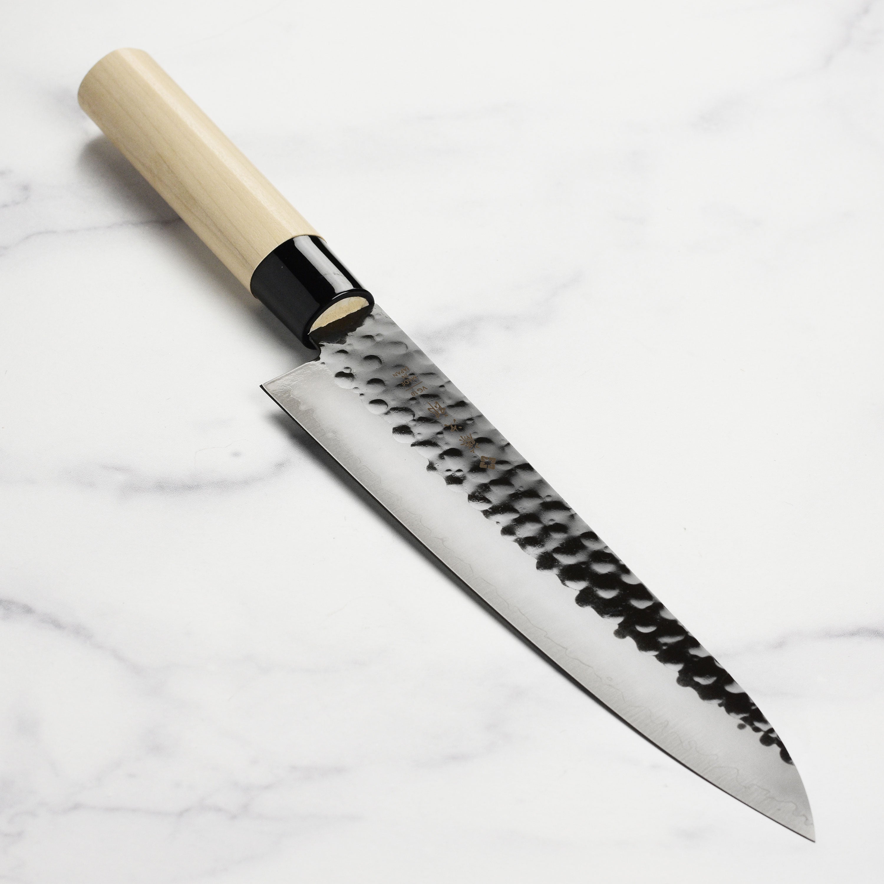 Hammered gyuto chef's knife with kurouchi finish, top view showing the blade's craftsmanship
