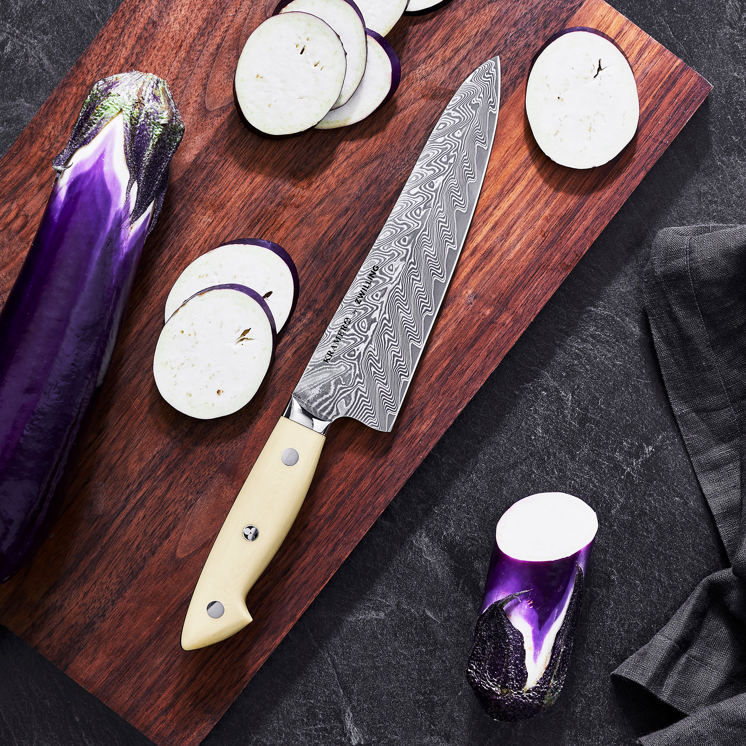 Kramer Cumulus 7" Santoku Knife showcasing the damascus pattern and micarta handle from a side angle.