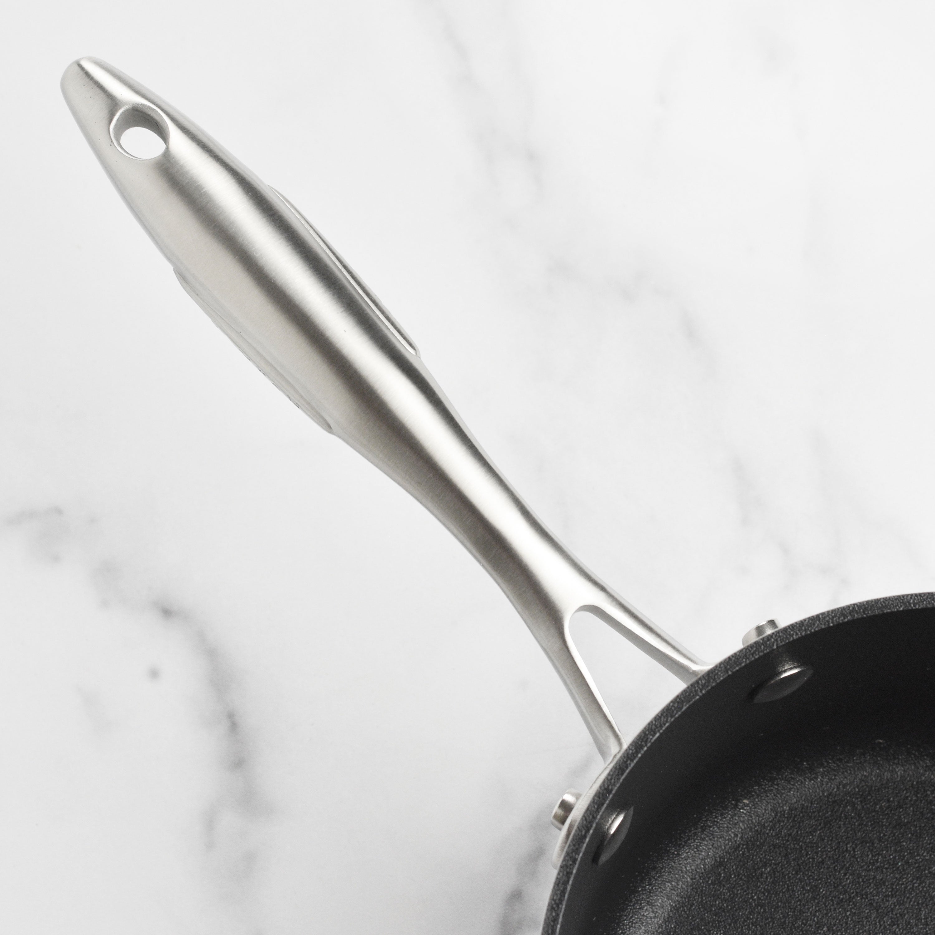 Cookware set with glass lids and stainless steel handles in a kitchen