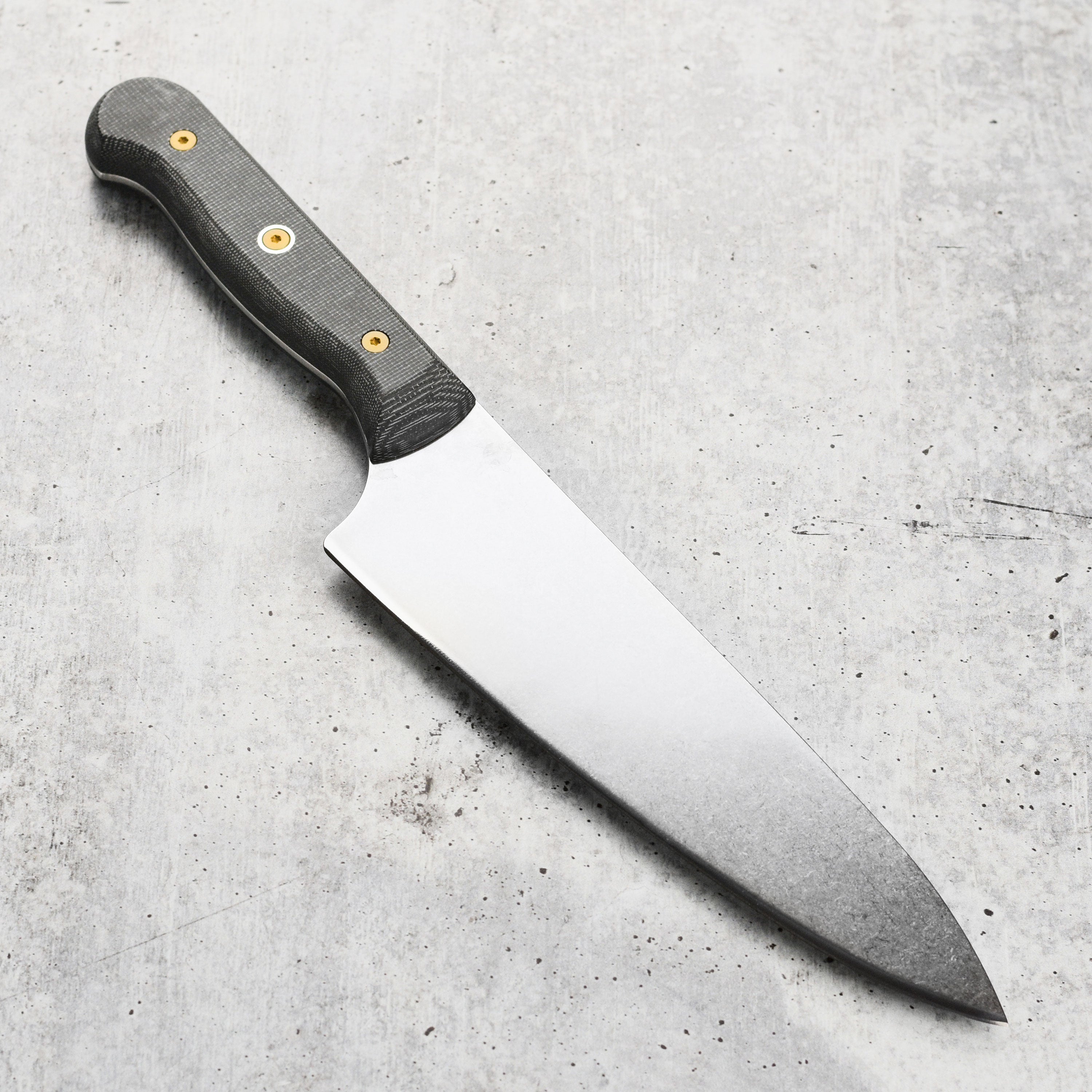 Angled shot of knife resting on wooden cutting board, showcasing premium craftsmanship and blade length.