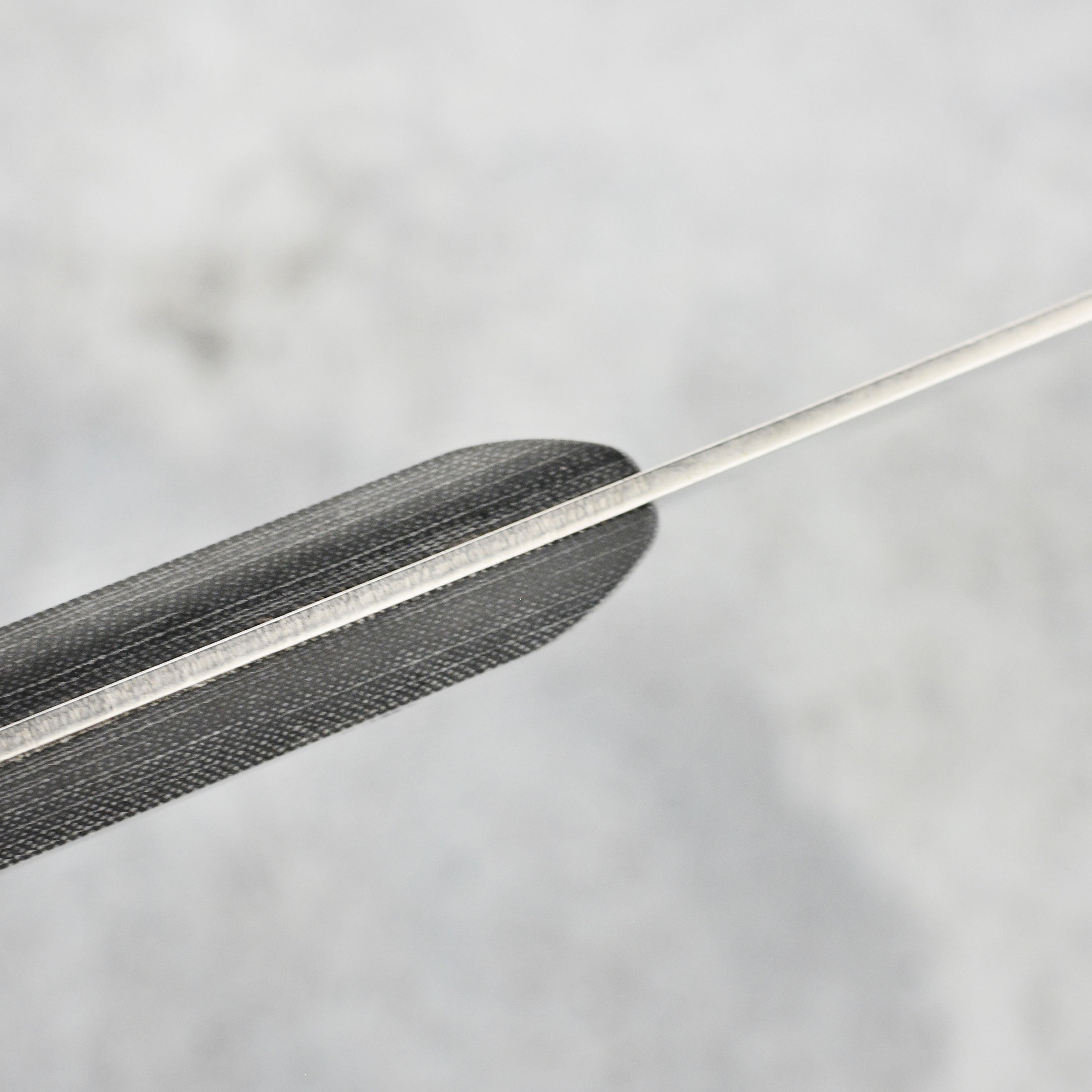 Angled shot of knife resting on wooden cutting board, showcasing premium craftsmanship and blade length.