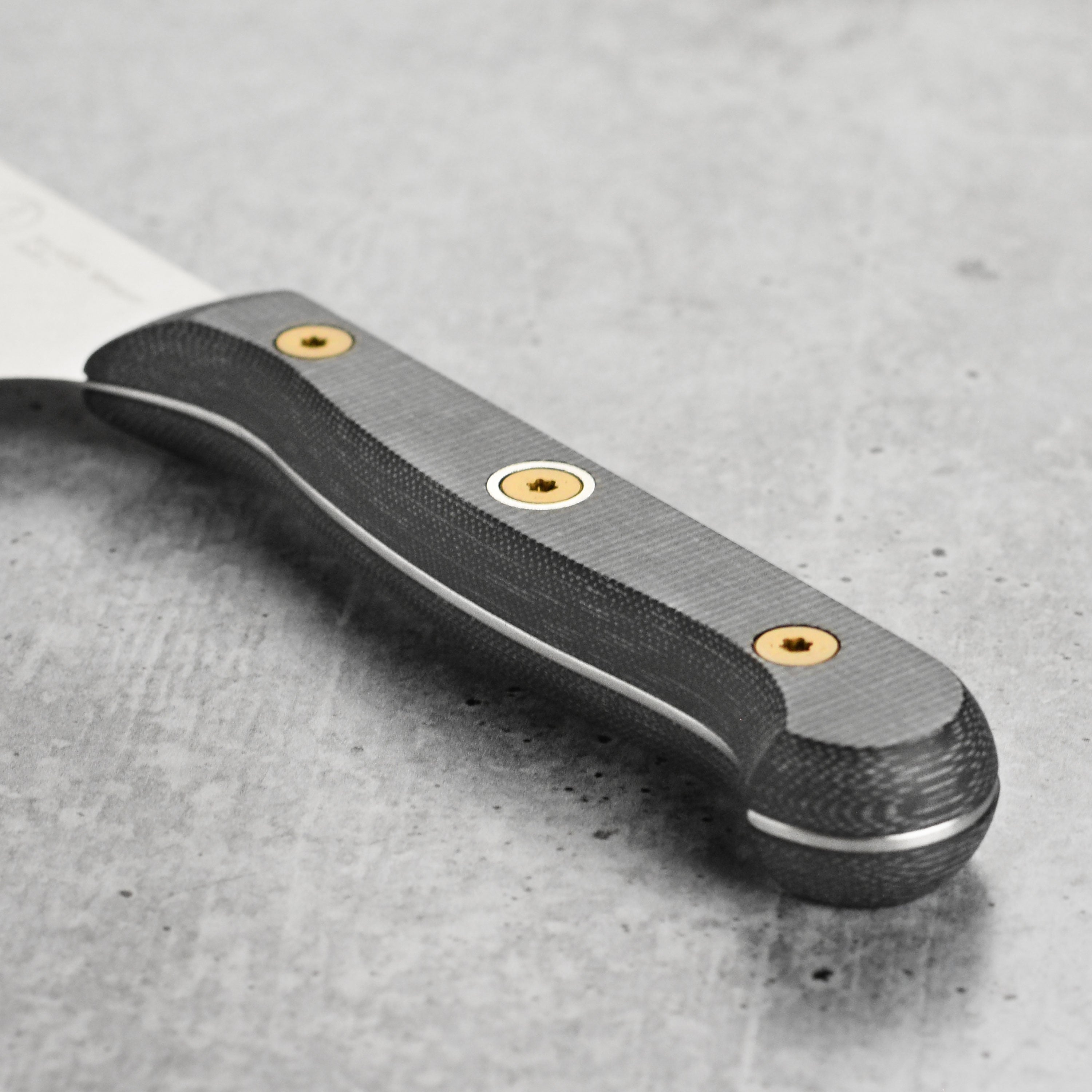 Messermeister Micarta utility knife being used to slice fresh vegetables, highlighting its sharpness and control.