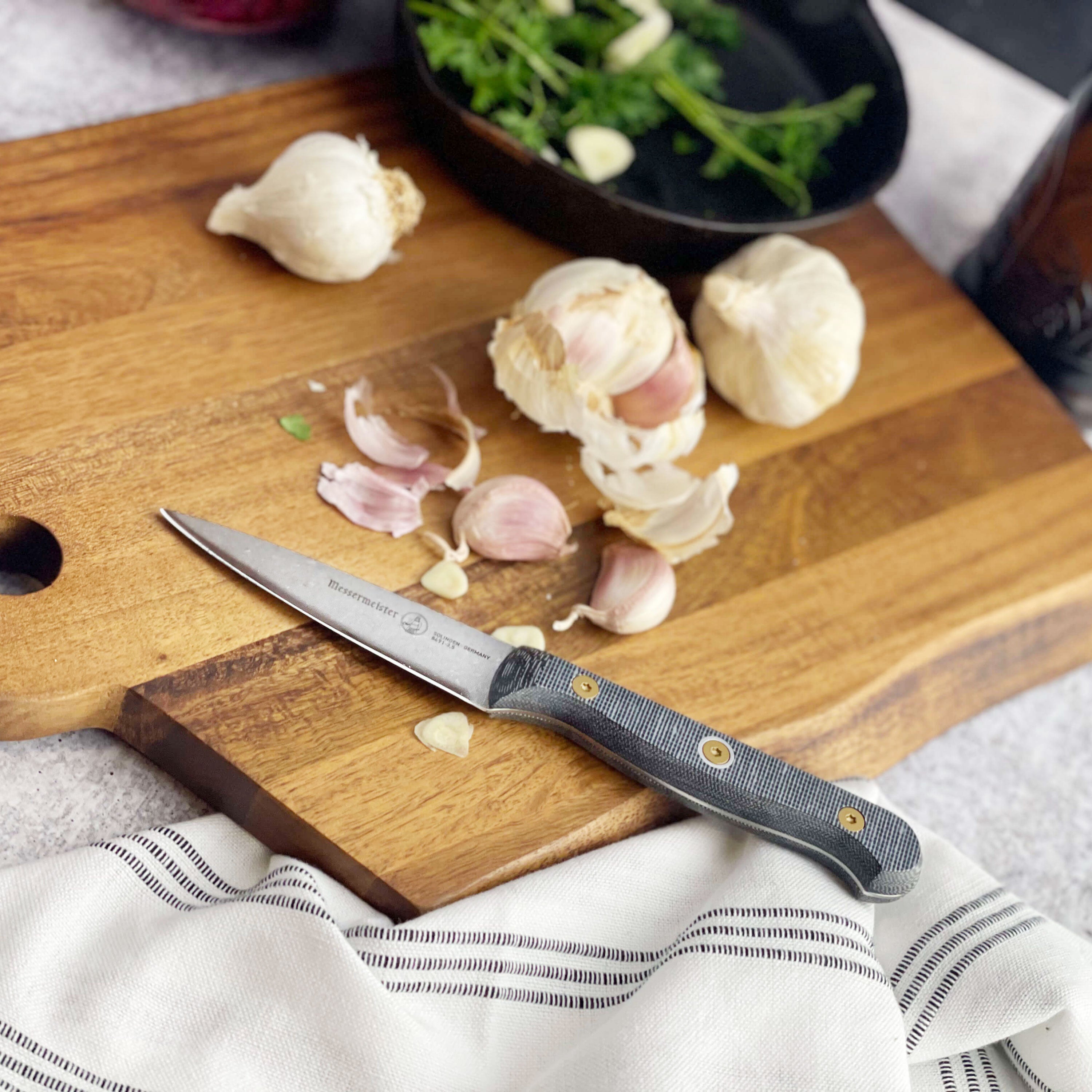 Messermeister Micarta paring knife in action, slicing fresh vegetables on a wooden cutting board.