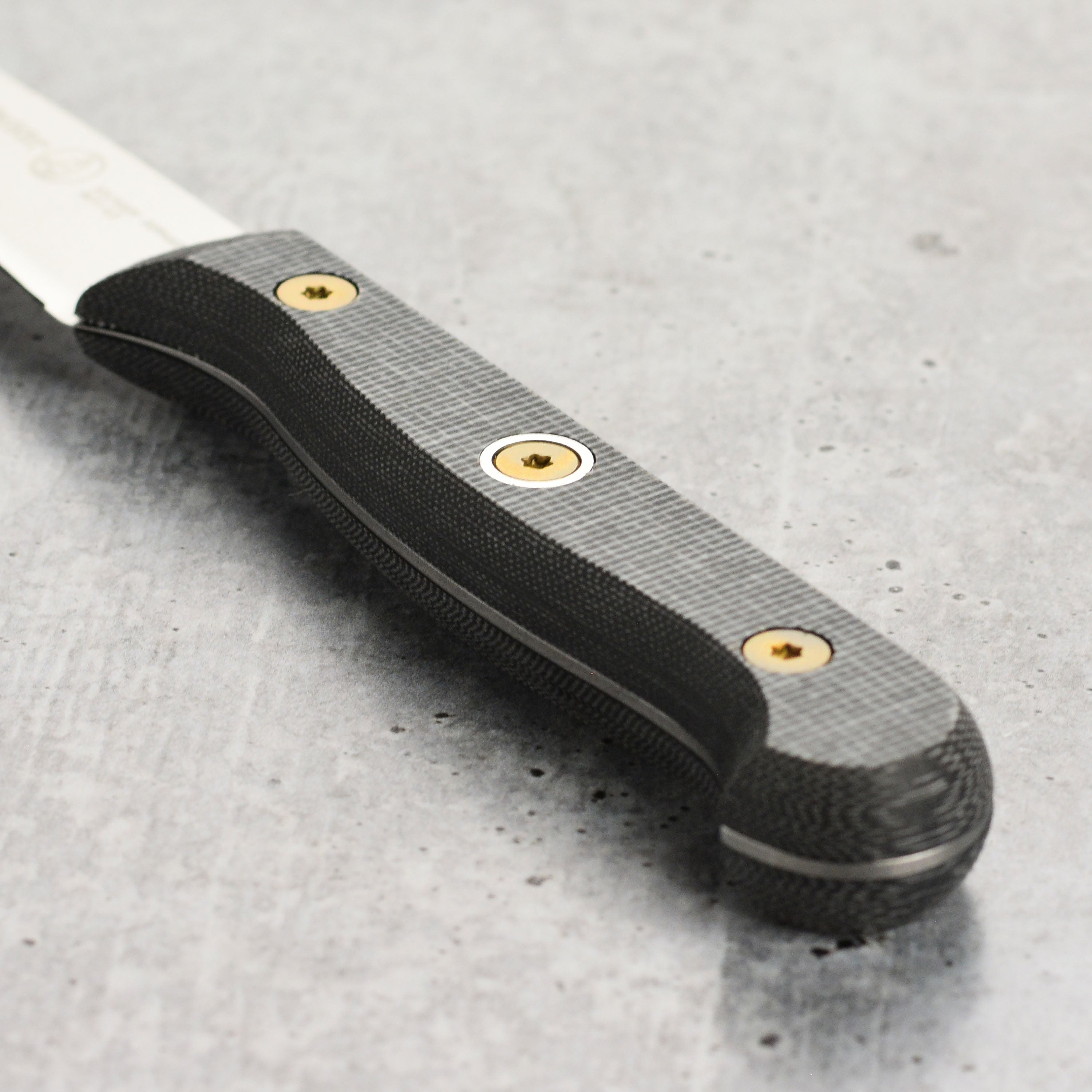 Messermeister Micarta paring knife in action, slicing fresh vegetables on a wooden cutting board.