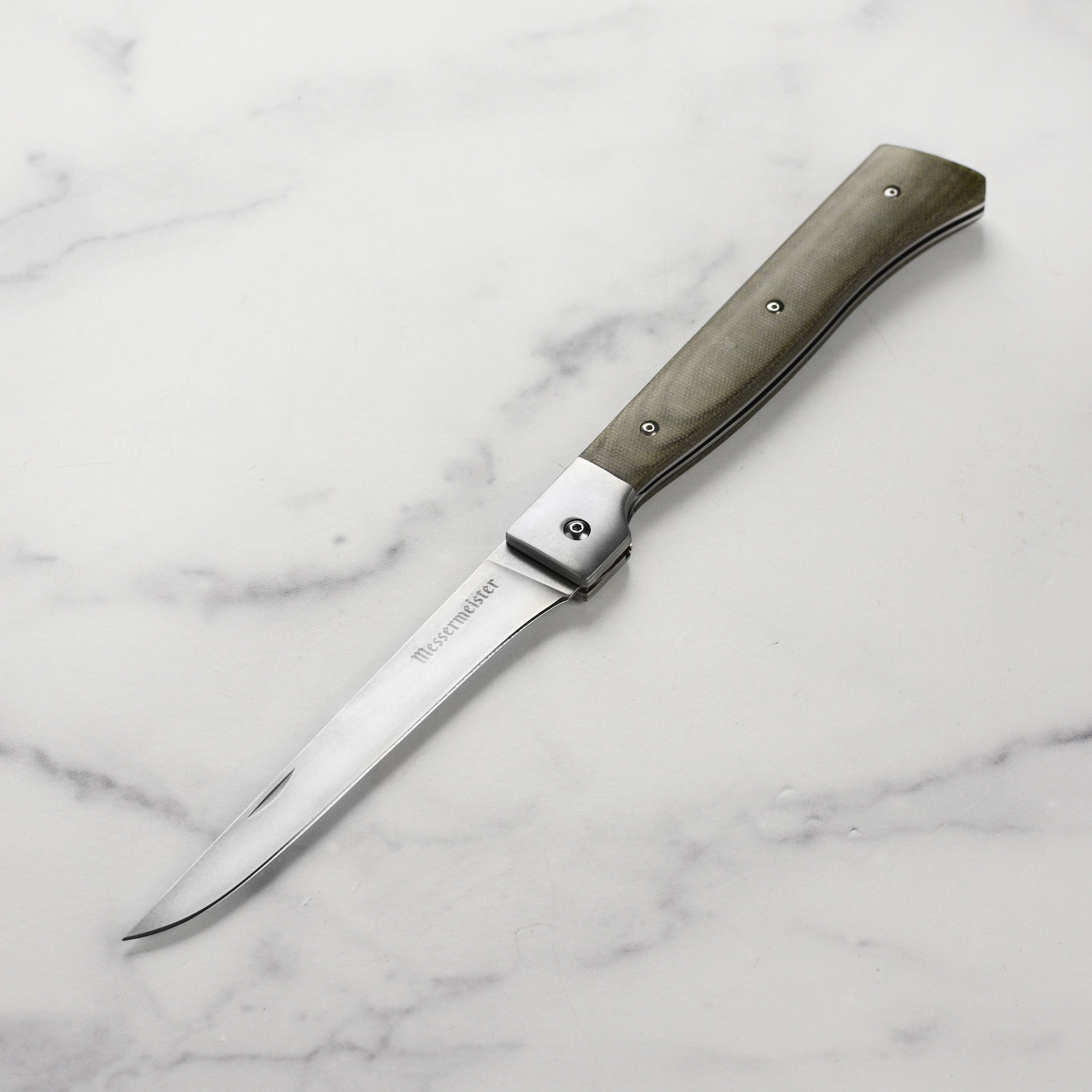 Close-up of the blade detailing on the Messermeister Adventure Chef folding fillet knife, showcasing the stonewash finish.