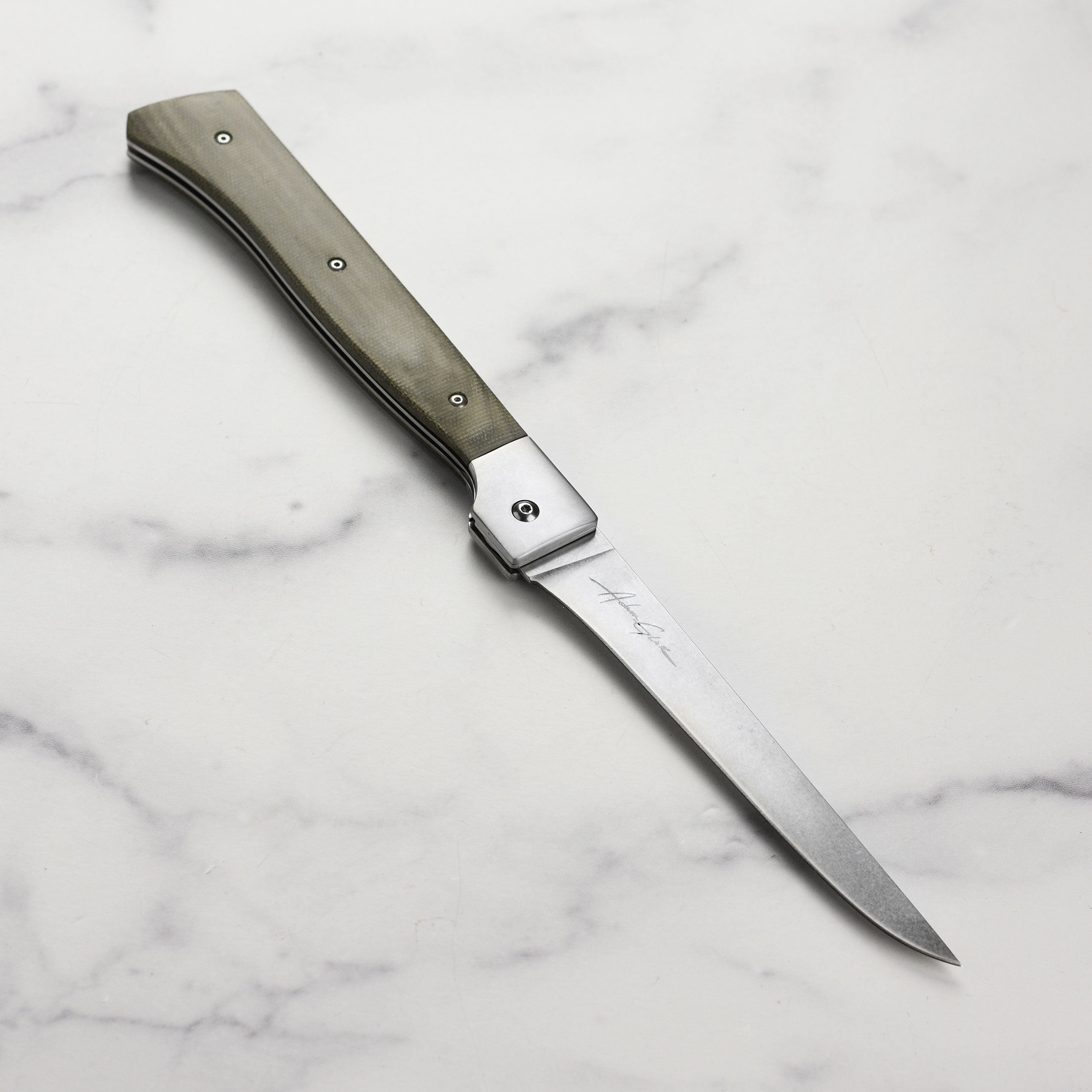 Messermeister Adventure Chef 6" folding fillet knife laid out beside fishing gear, perfect for outdoor adventures.