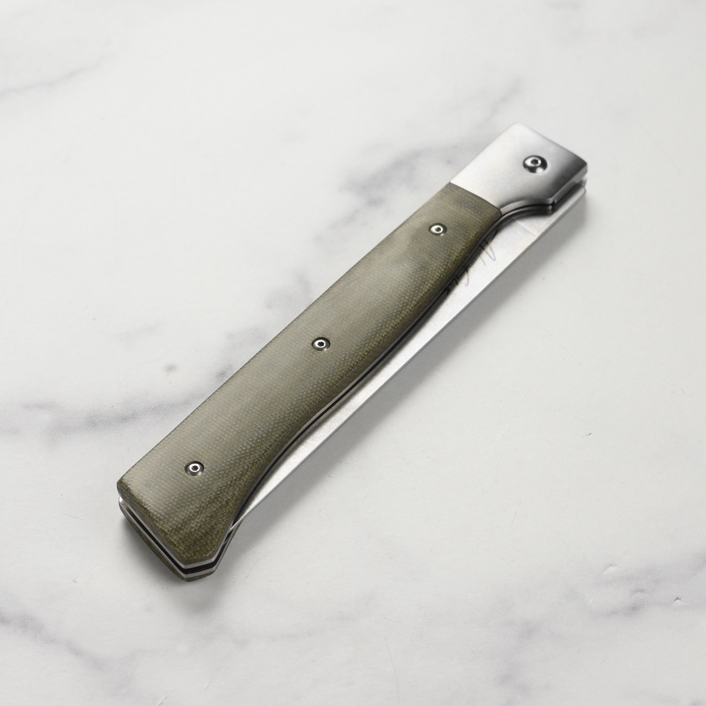Close-up of the blade detailing on the Messermeister Adventure Chef folding fillet knife, showcasing the stonewash finish.