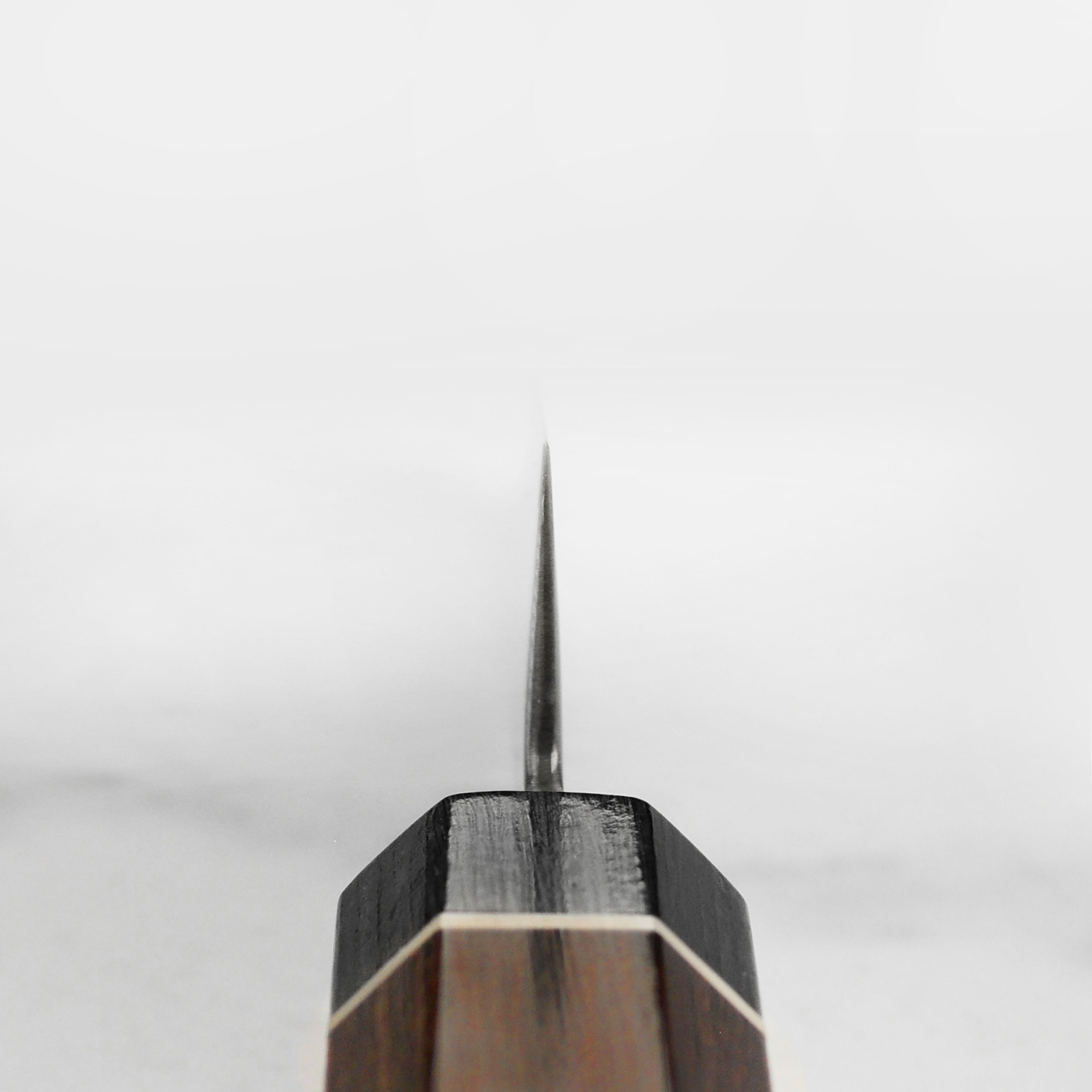 Close-up of the dark patterned Damascus blade with a Pakkawood handle