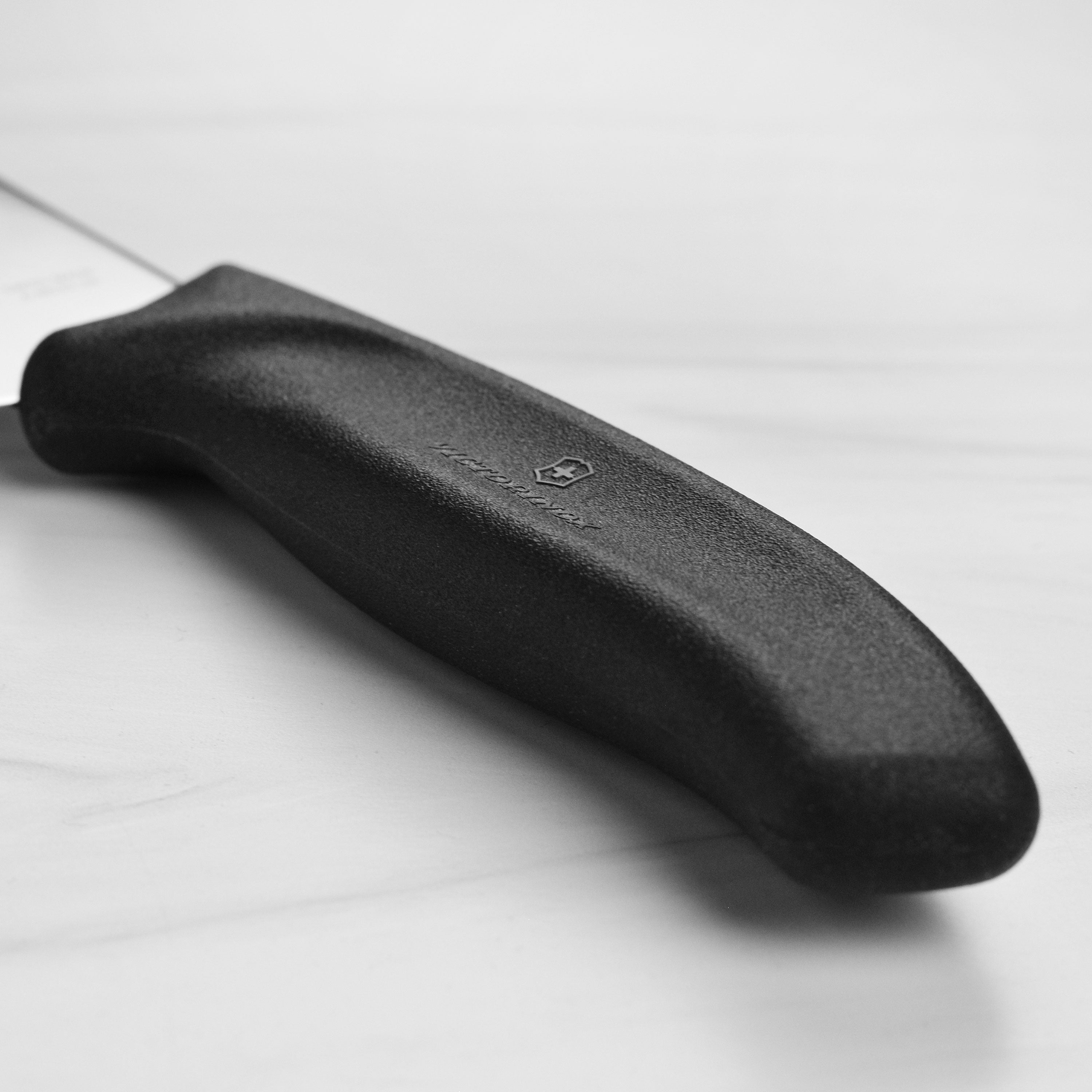 Chef using a flexible boning knife to debone poultry in a professional kitchen