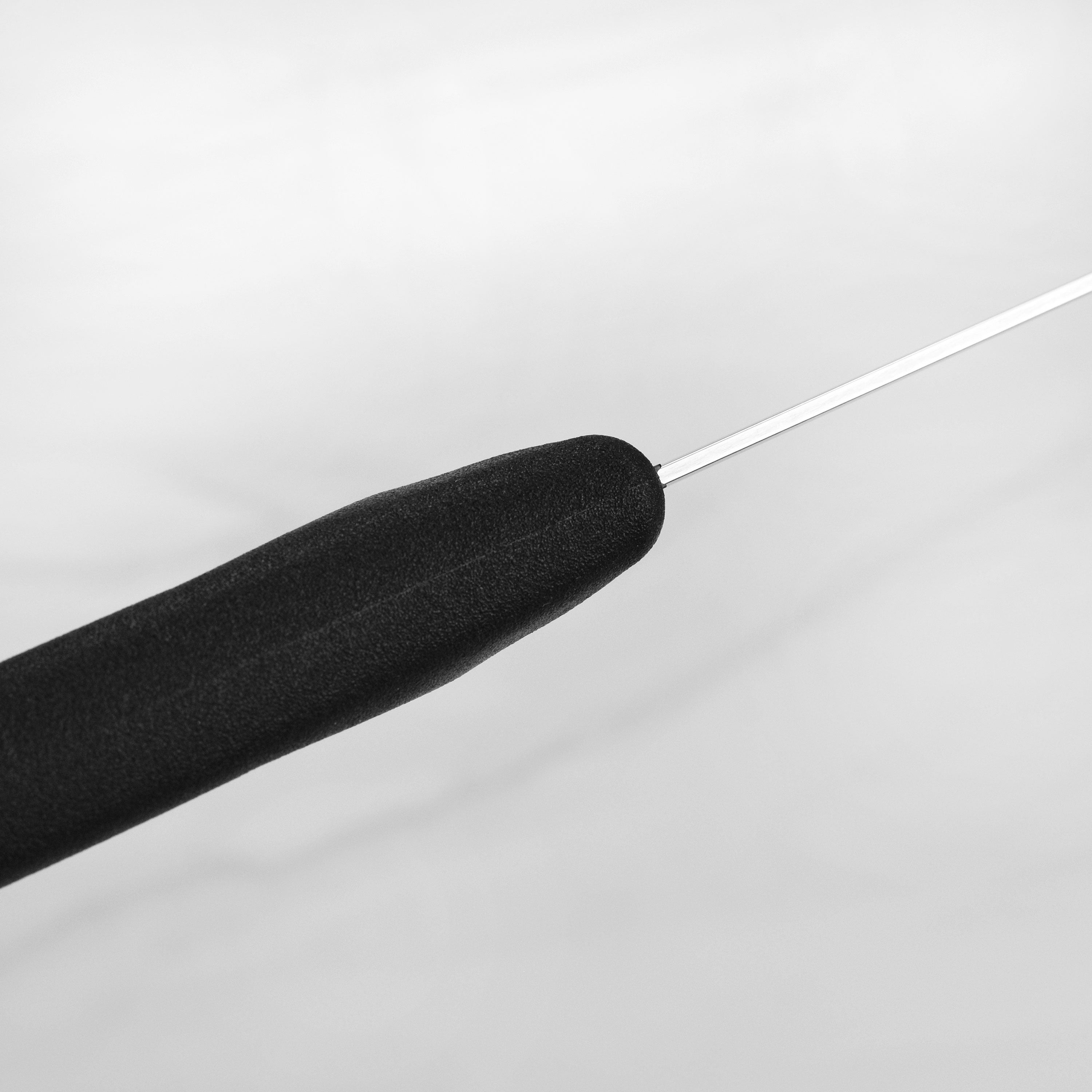 Swiss chefs knife displayed with fresh vegetables to demonstrate its cutting capability.
