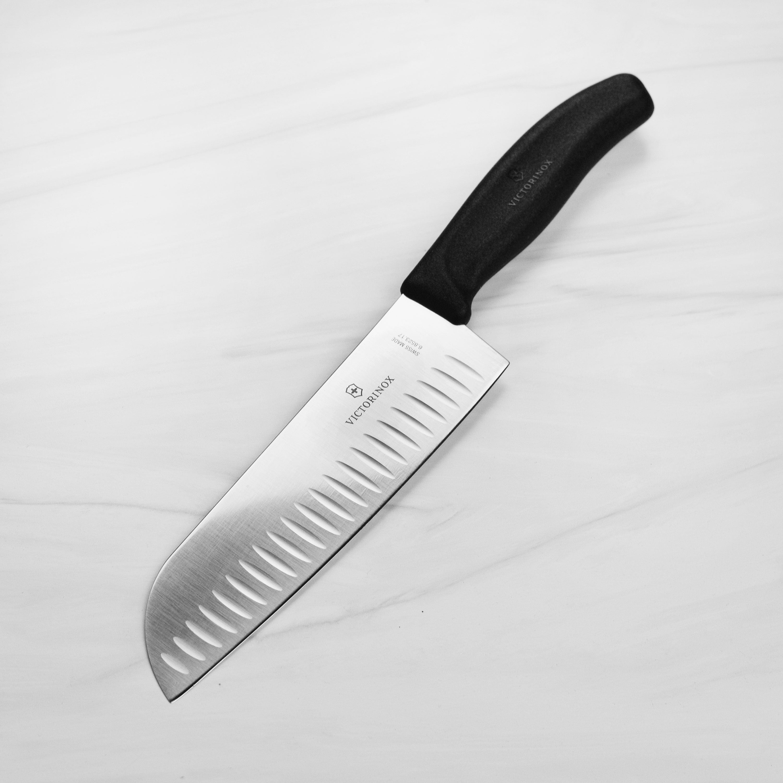 Victorinox Swiss Classic Santoku knife with hollow edge on a cutting board