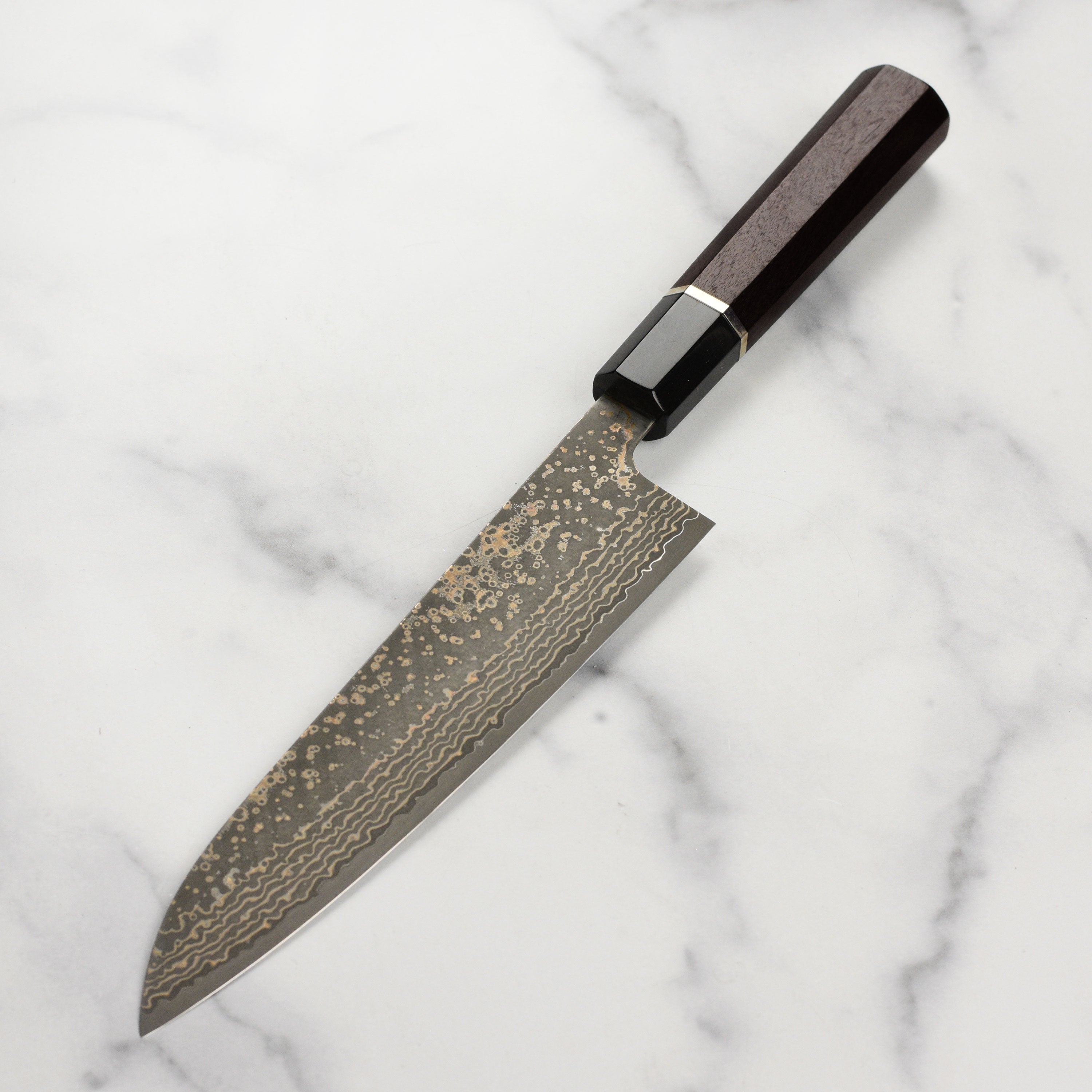 Close-up of the Saji Black Gold Damascus knife, highlighting its detailed blade design and craftsmanship.