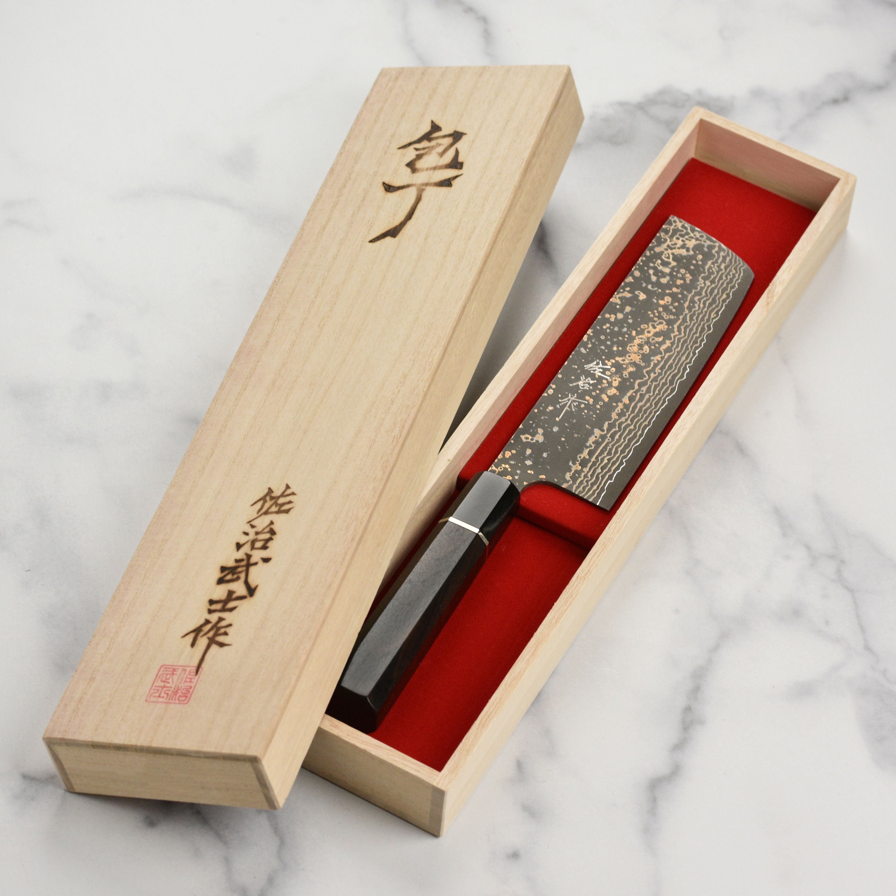 Saji Black Gold Damascus Nakiri in a kitchen setting with vegetable slicing