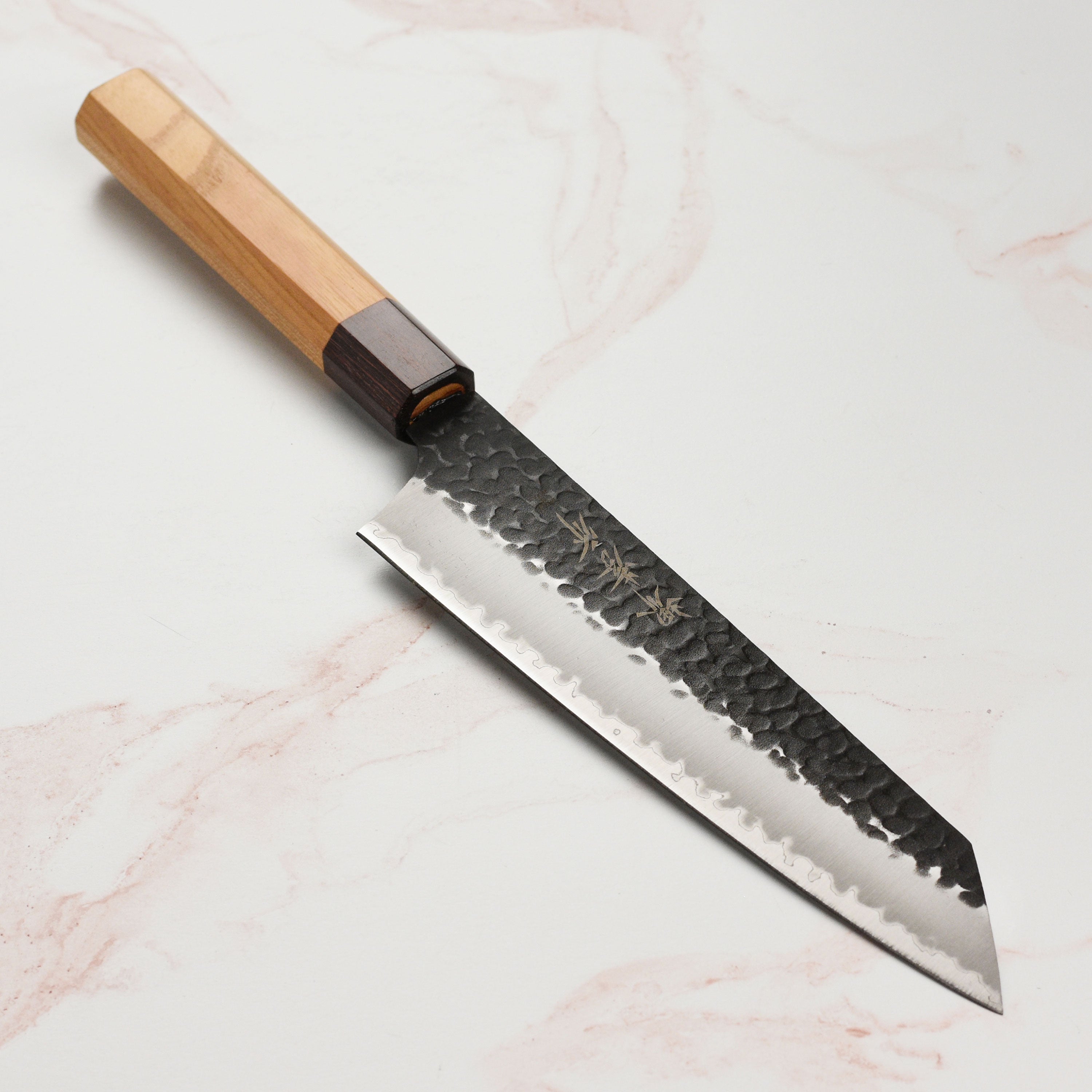 Side view of the Takayuki Aogami Kiritsuke knife highlighting the hammered finish and sharp edge.